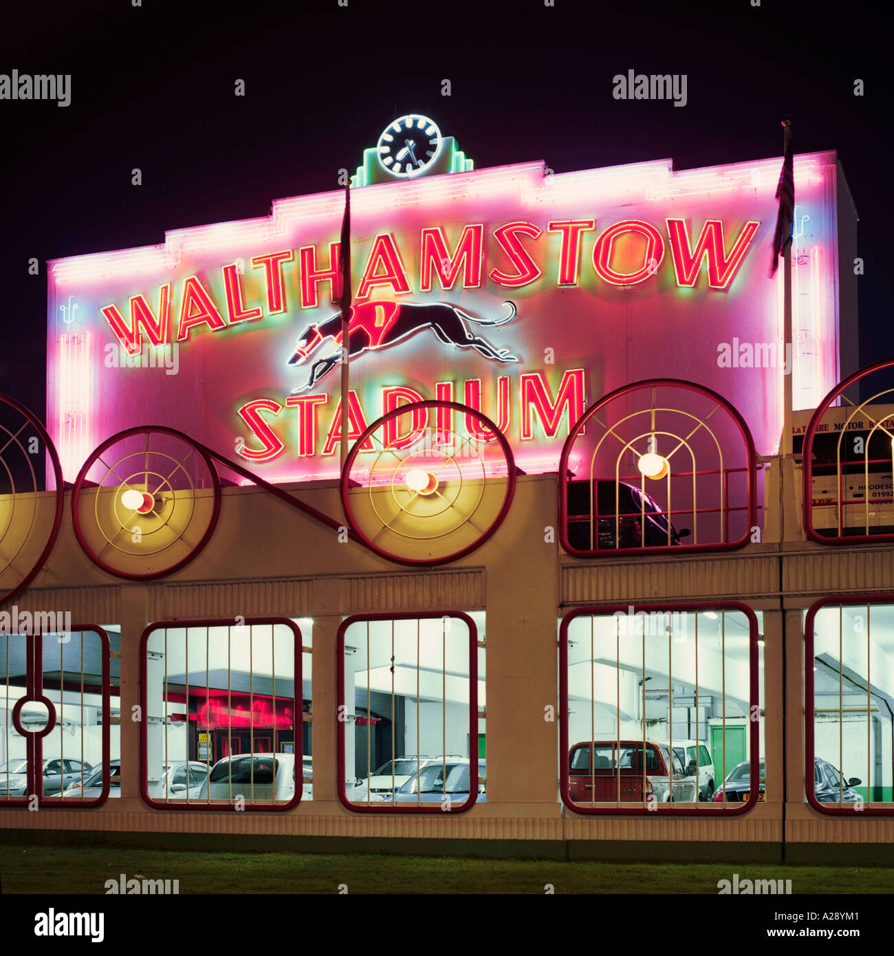 Nachtaufnahme Fassade von Walthamstow Dog Racing Track; Inc-Neon-Schilder und Parkplatz Stockfoto