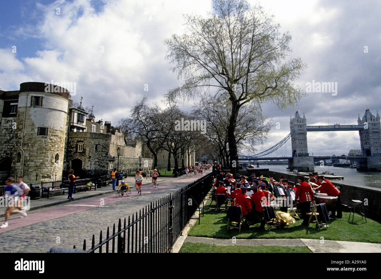 Läufer in den London-Marathon kommen vorbei an der Tower of London spielt die Band neben der Themse Stockfoto