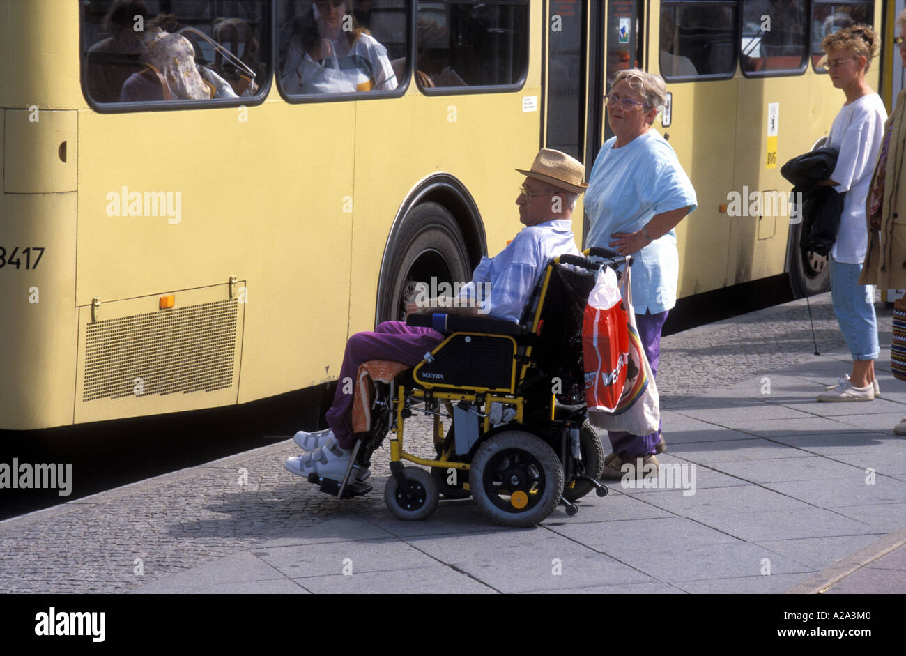 Deutschland Berlin Mann im Rollstuhl an einer Bushaltestelle warten Stockfoto