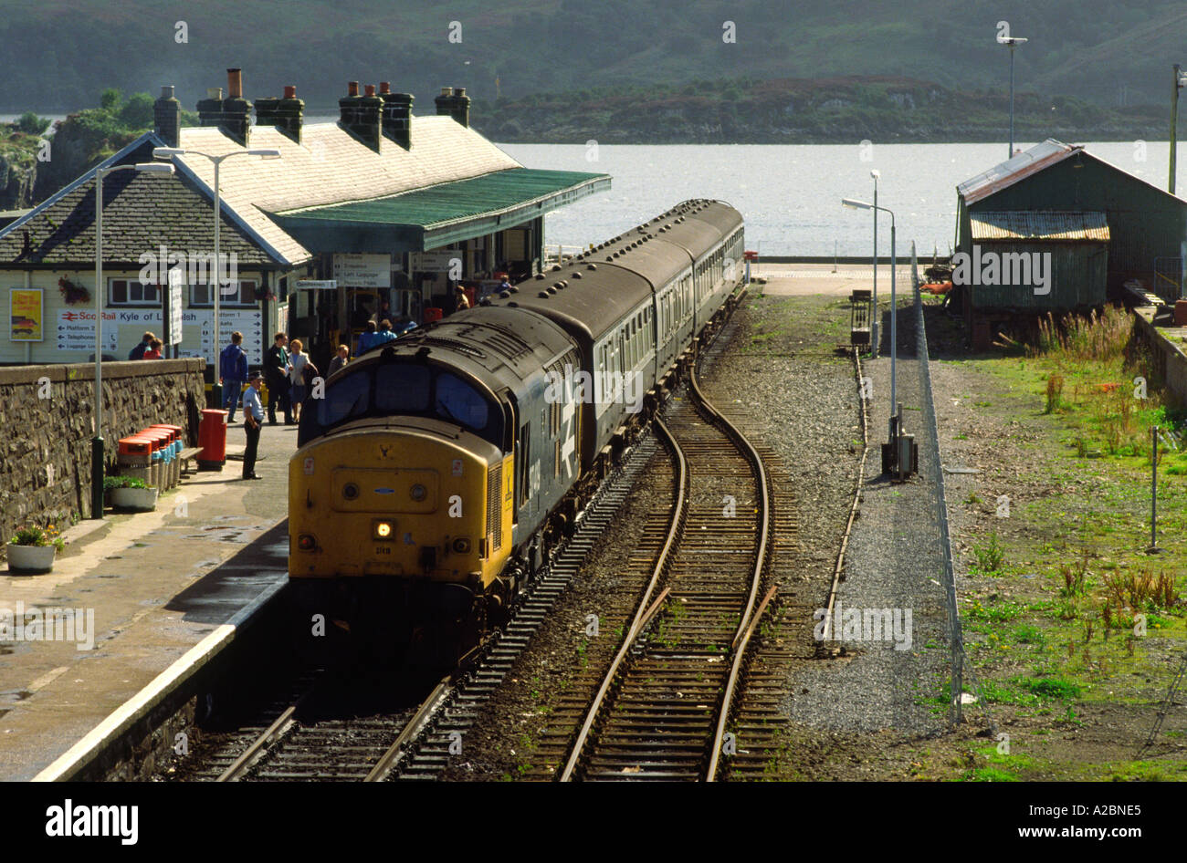 Diesellokomotive und -Trainer der Klasse 37 am Bahnhof Kyle of Lochalsh in den 1980er Jahren, schottische Highlands mit der Insel Skye im Hintergrund. Stockfoto