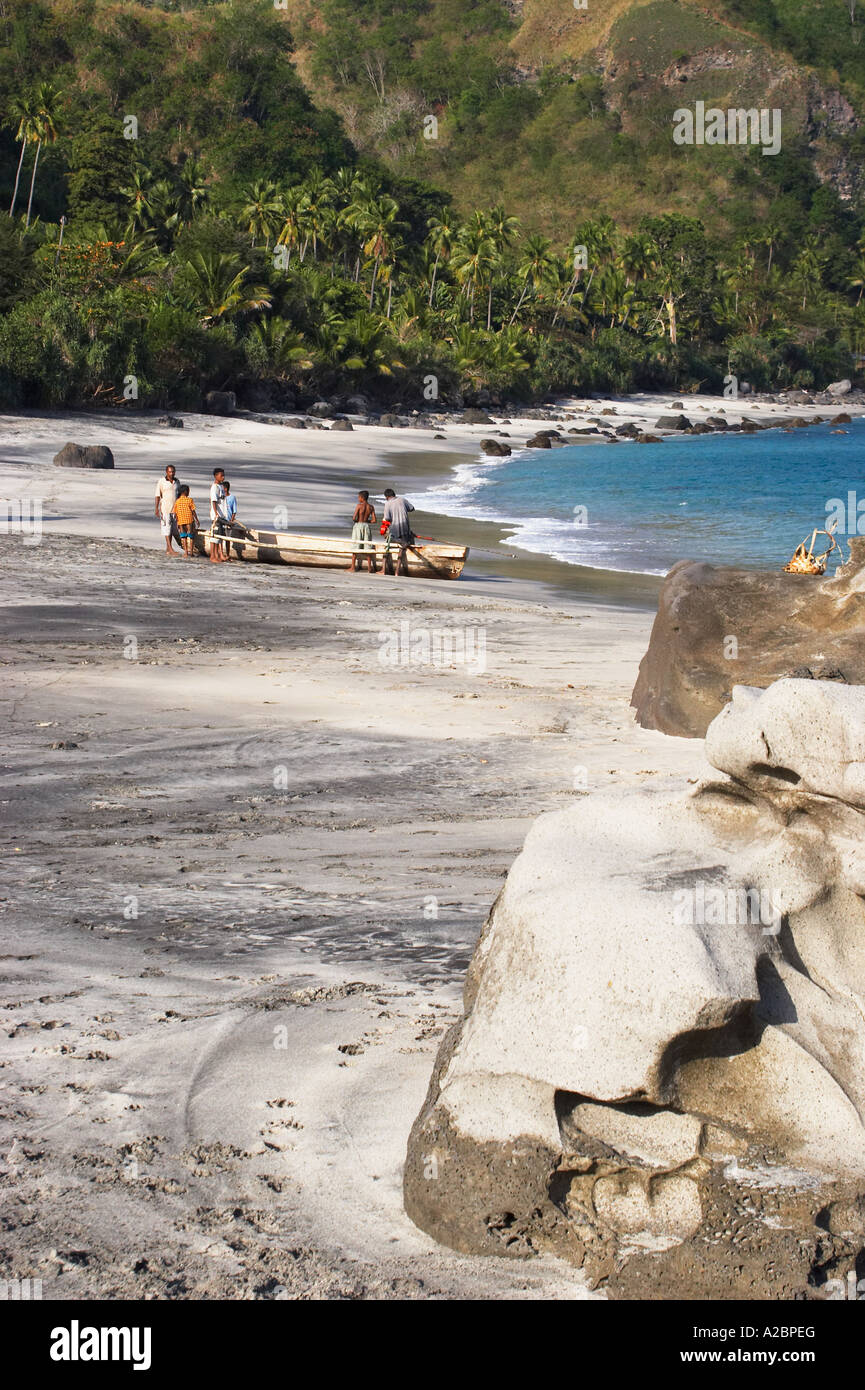 Tropical Beach, Dorfbewohner und Fischerboot Stockfoto