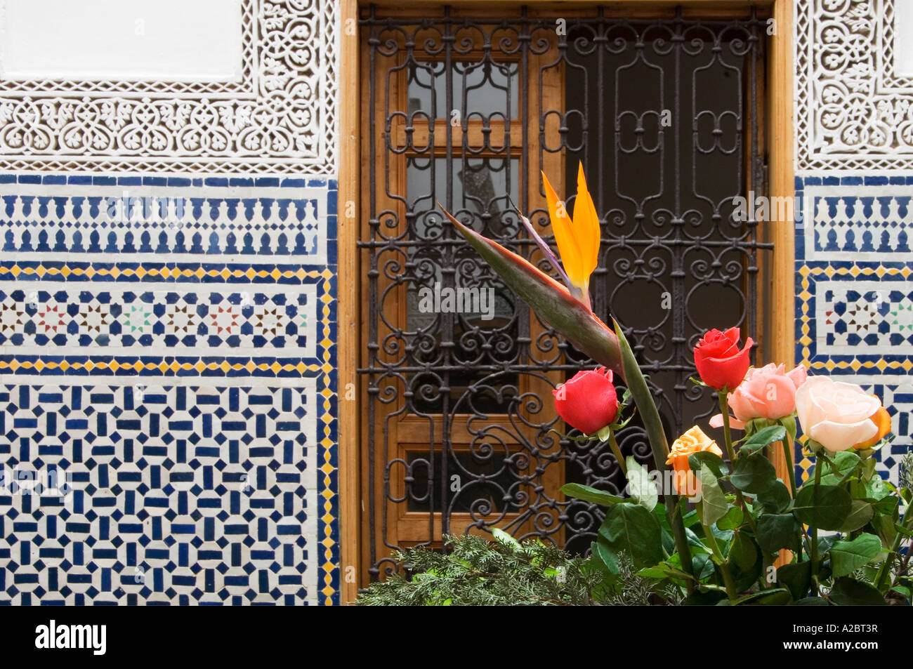 Hübsche Blumen gegen Fenster ausgekleidet mit Zilij in traditionellen restaurierten Gästehaus Riad Cle De Fes Fes Marokko Stockfoto