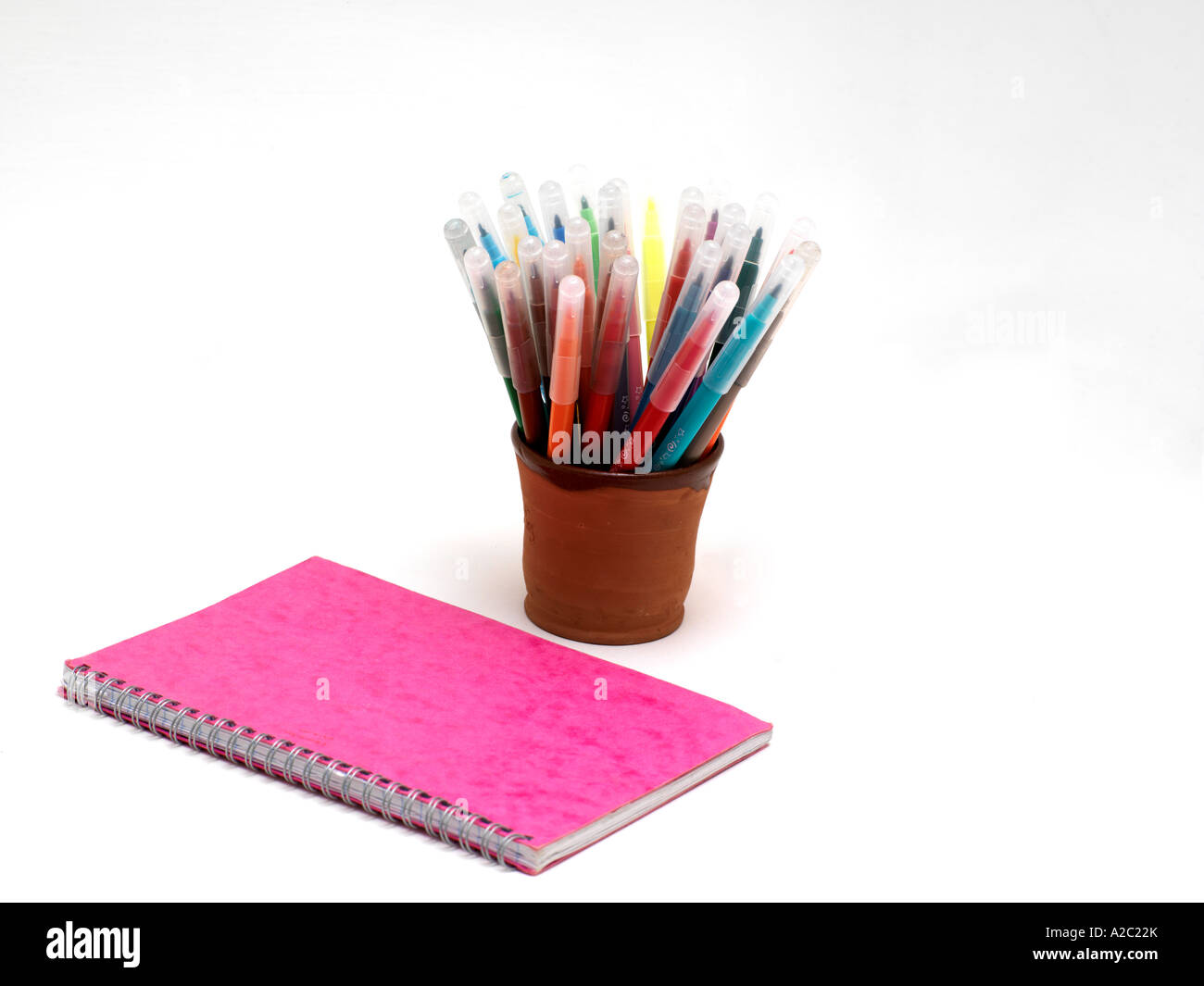 Topf mit farbigen Filz Spitze Stifte und rosa Notebook Stockfoto
