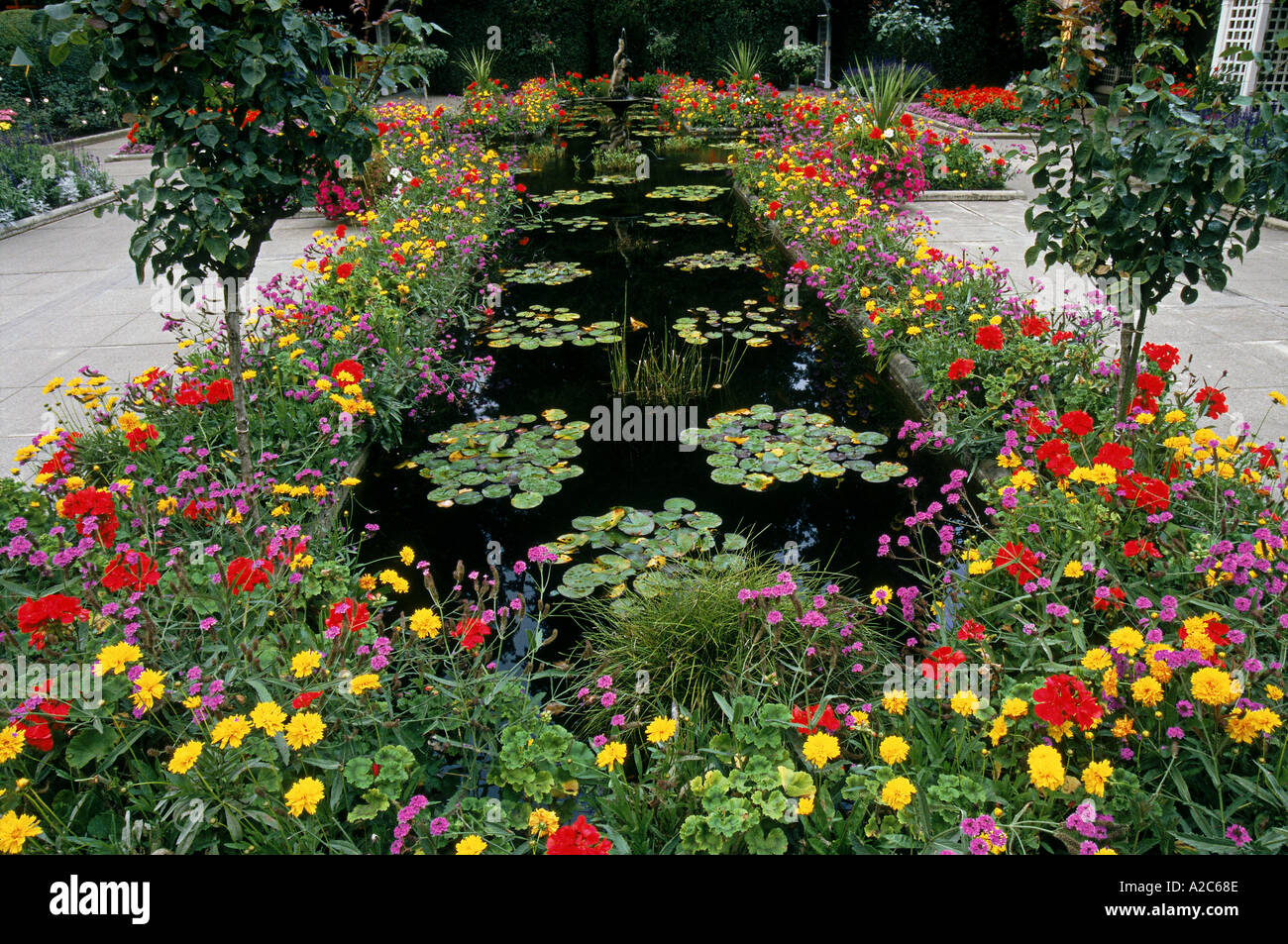 Horizontalen Schuss von Teich, umgeben von bunten Blumen in Butchardt Gärten Kanada Stockfoto