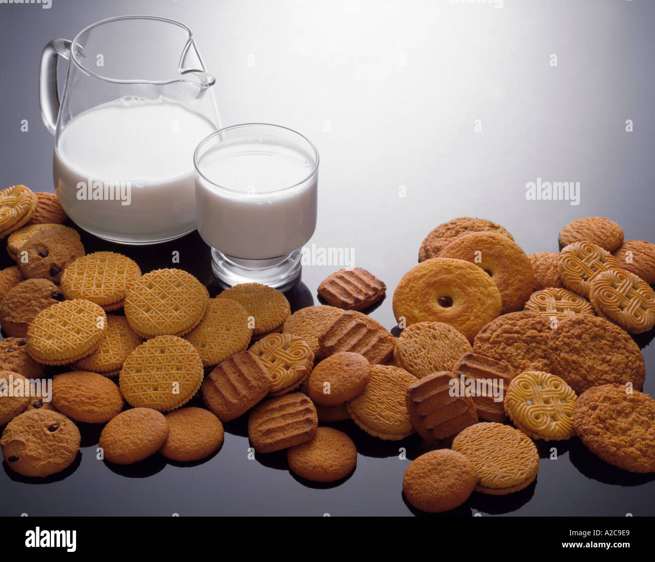 Milch und Kekse Vielfalt Anordnung auf reflektierenden Hintergrund Stockfoto