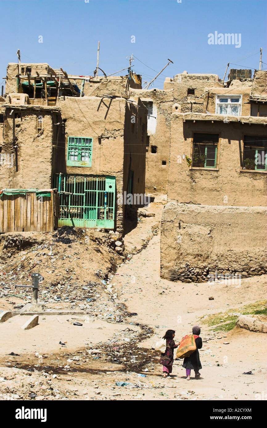 AFGHANISTAN Ghazni Kinder laufen mit Säcken über die Schulter in Richtung Häuser innerhalb der alten Mauern der Zitadelle Stockfoto