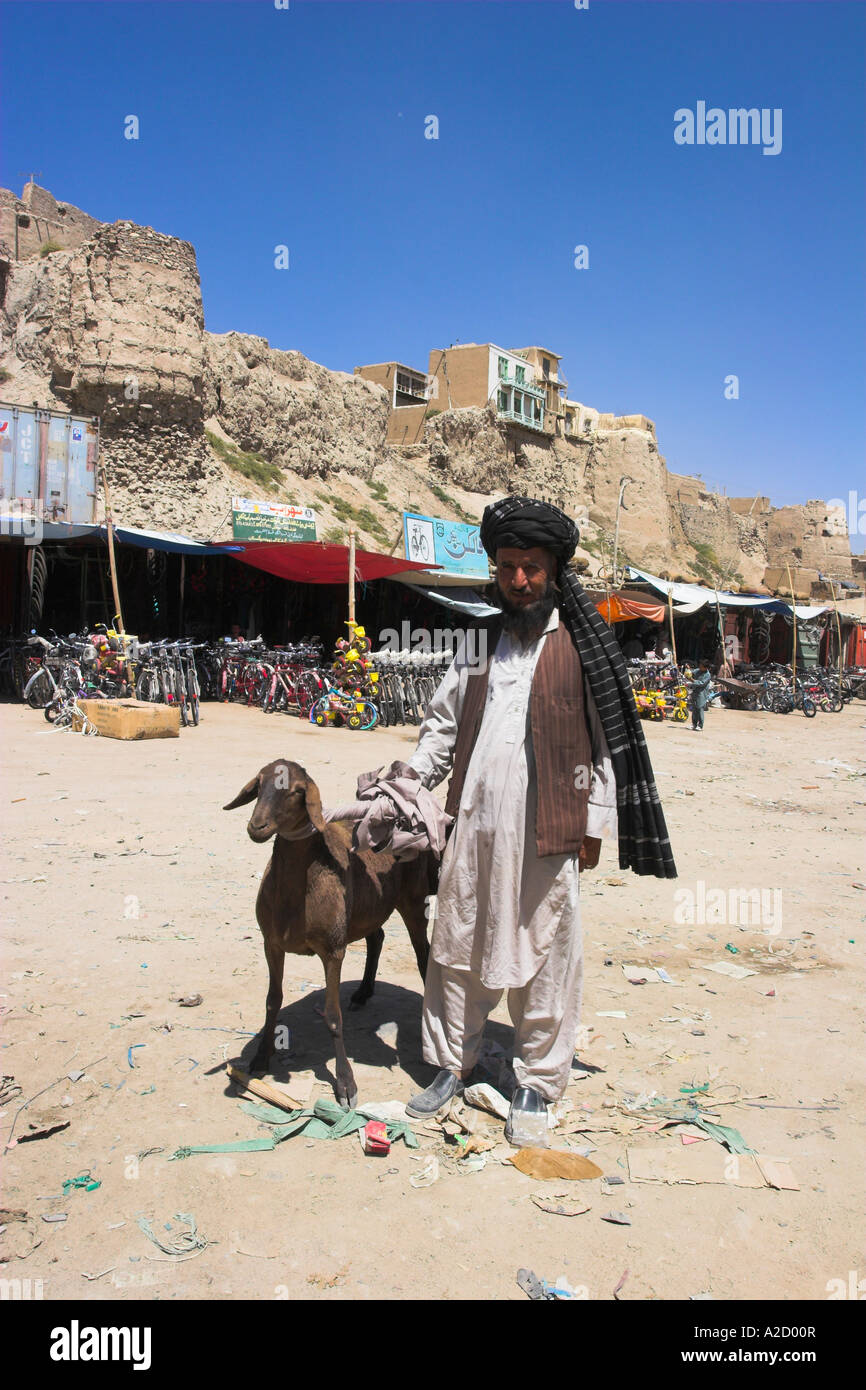 AFGHANISTAN Ghazni Mann mit Ziege entlang der Straße in der Nähe von alten Mauern der Zitadelle Stockfoto