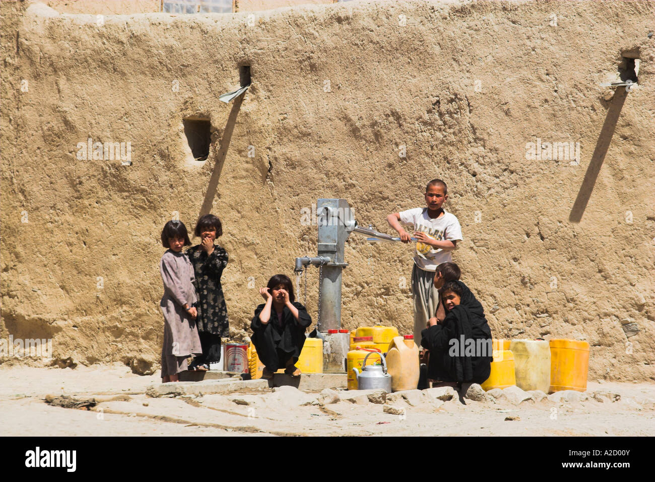 AFGHANISTAN Ghazni Kinder füllen Sie Wasser-Container am Brunnen in der Nähe von Häusern in alten Mauern der Zitadelle Stockfoto