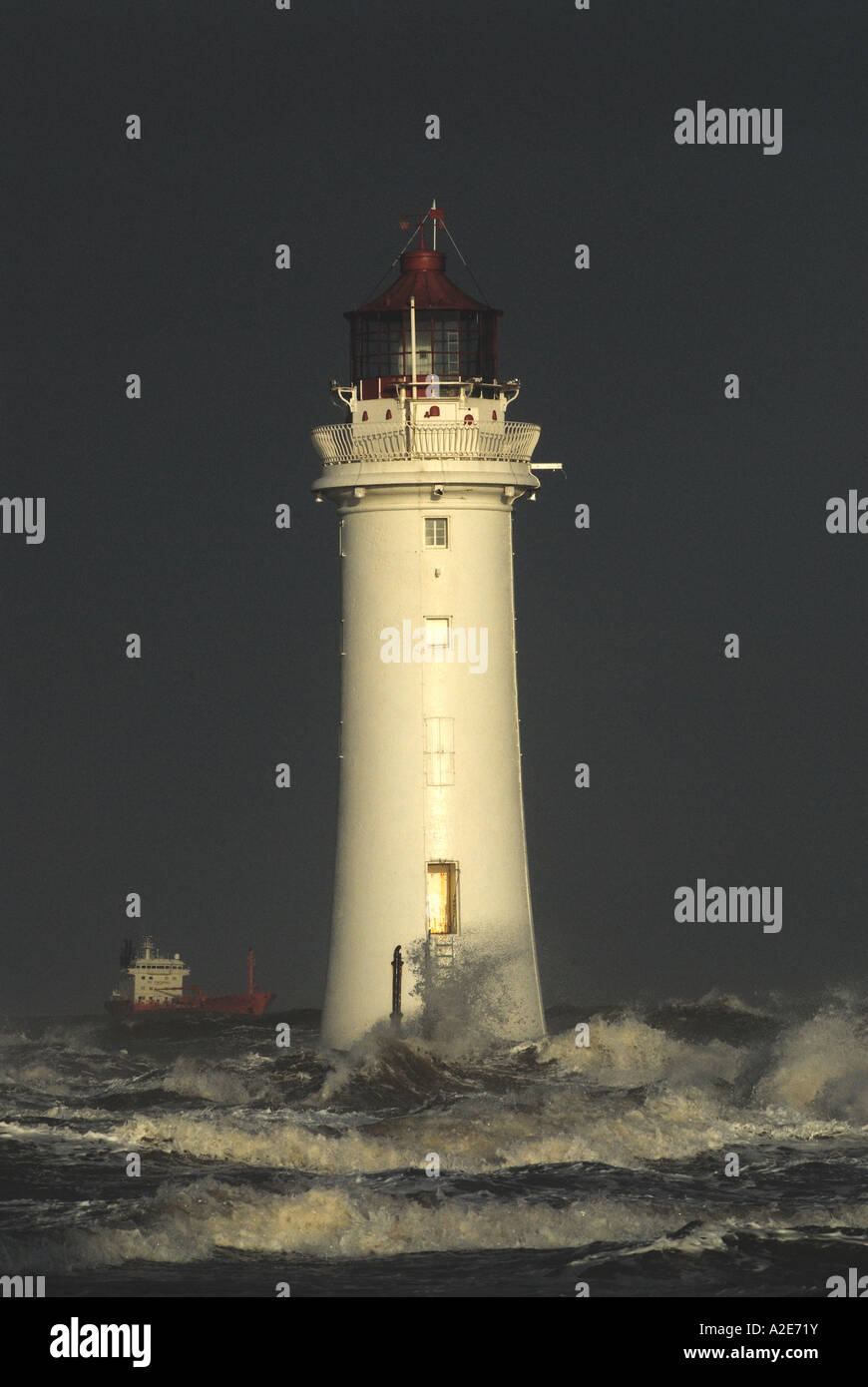 Barsch Rock Leuchtturm in stürmischer See, während ein Schiff in der Ferne geht Stockfoto