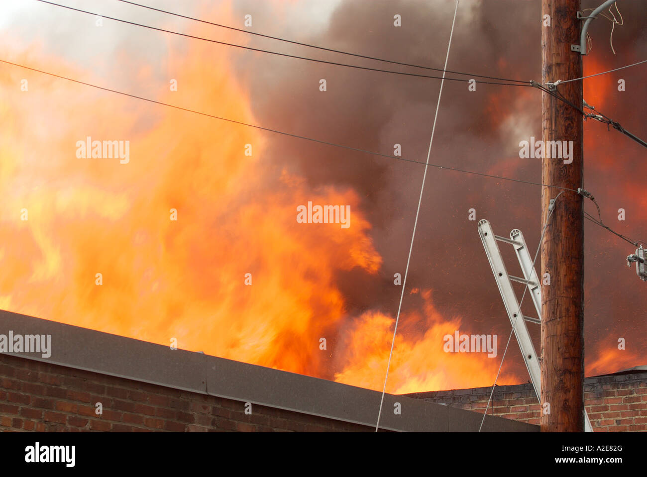 Schwere Flammen schießen aus dem Dach einer kommerziellen Lagerhalle voller Möbel in Wenatchee WA USA Stockfoto