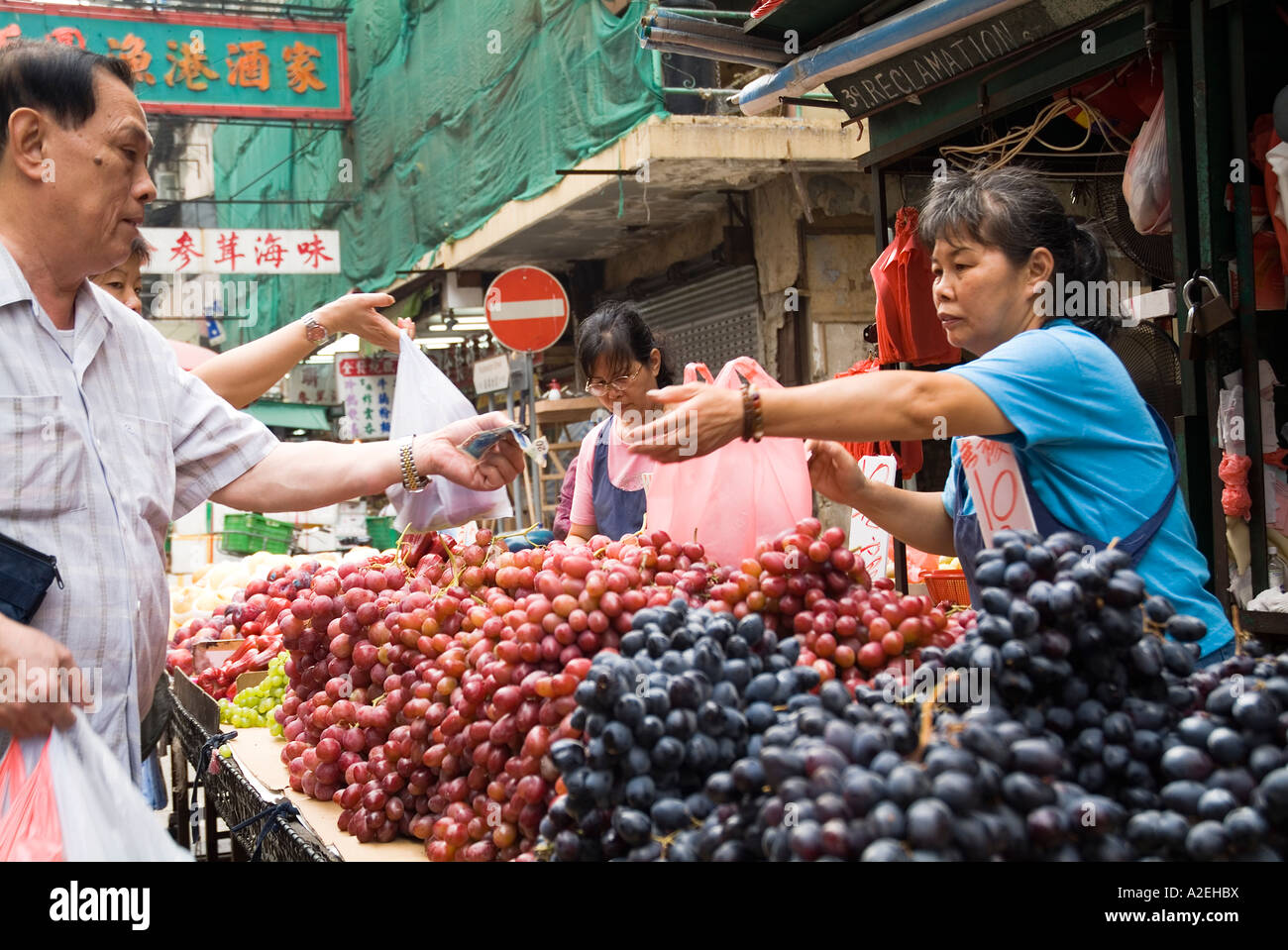 dh Jordan Obstmarkt YAU MA TEI HONG KONG chinesischen Stallholder Verkäufer Trauben zur Kundenanzeige kowloon Menschen Straße Stall Gemüsehändler Besitzer lokal Stockfoto