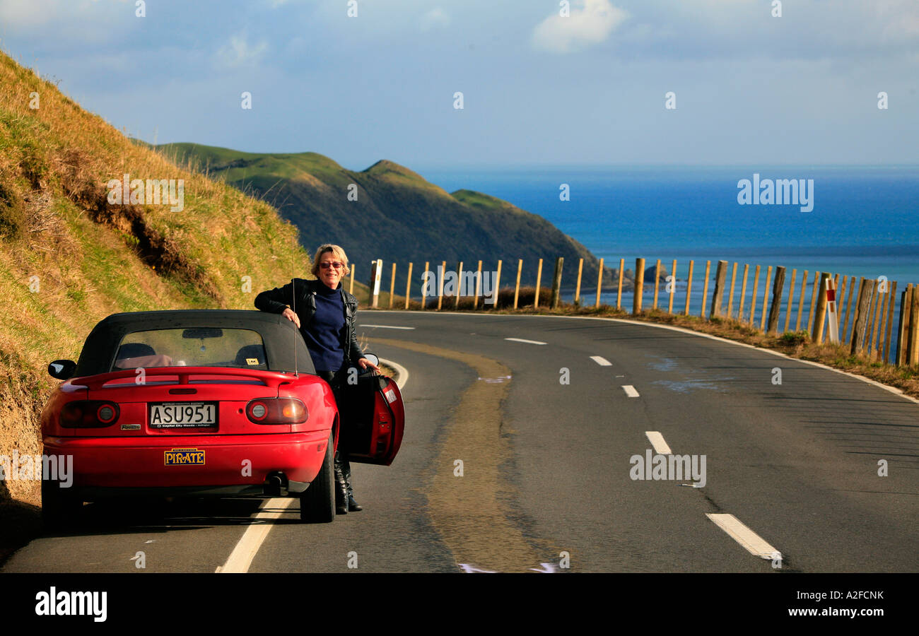 Ein roten Mazda Sportscar und Frau Treiber bewundert die Landschaft in der Nähe von Paekakariki Wellington New Zealand Stockfoto