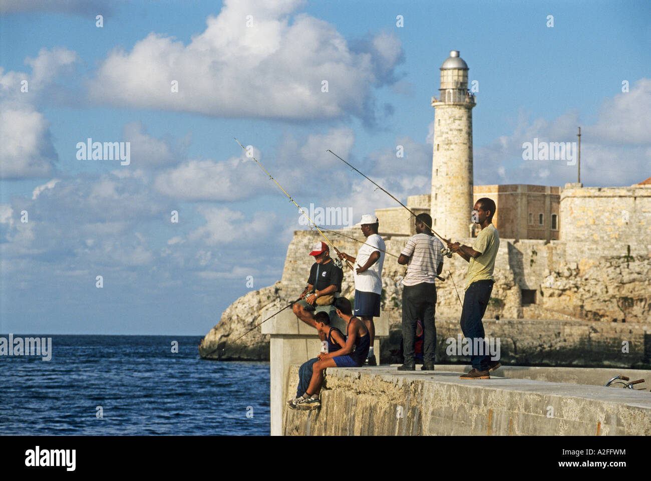 Angler an der Uferpromenade Malecon, Festung El Morro im Hintergrund, Havanna, Kuba Stockfoto