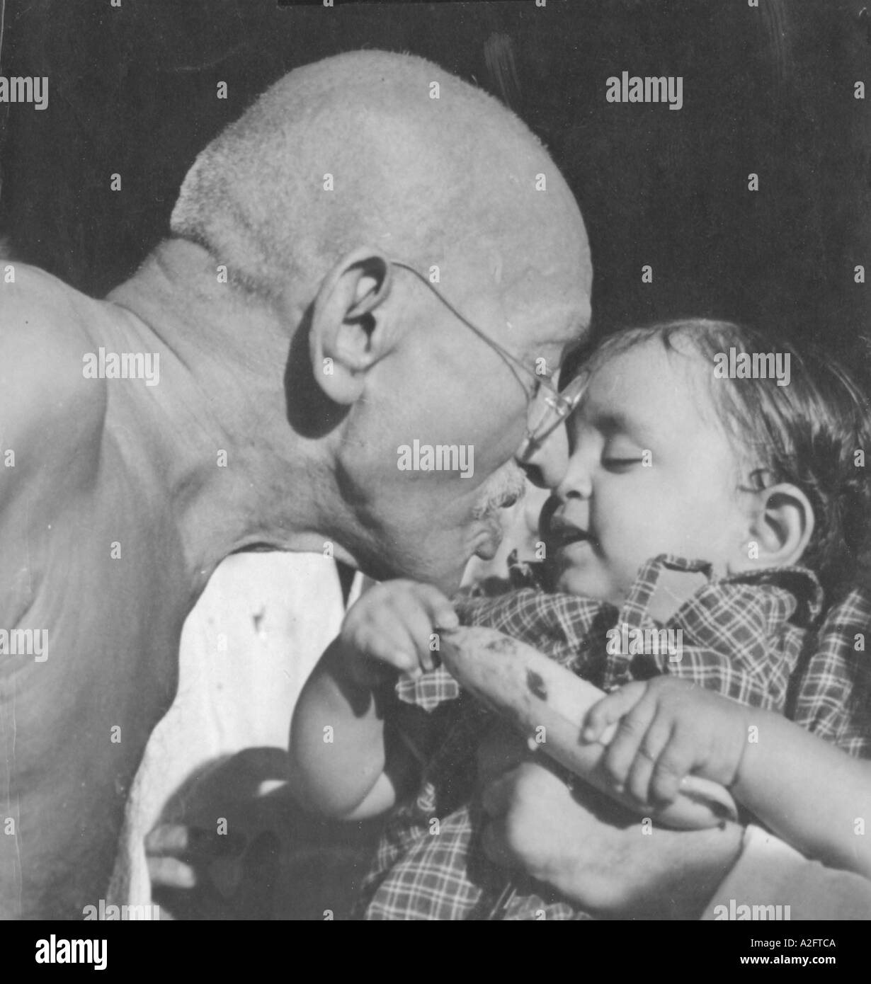 Mahatma Gandhi Zuneigung zeigen und die Banane zu Nandini Nichte von Gandhi Sekretär Pyarelal Nayer Sewagram Ashram in Indien 1944 Stockfoto