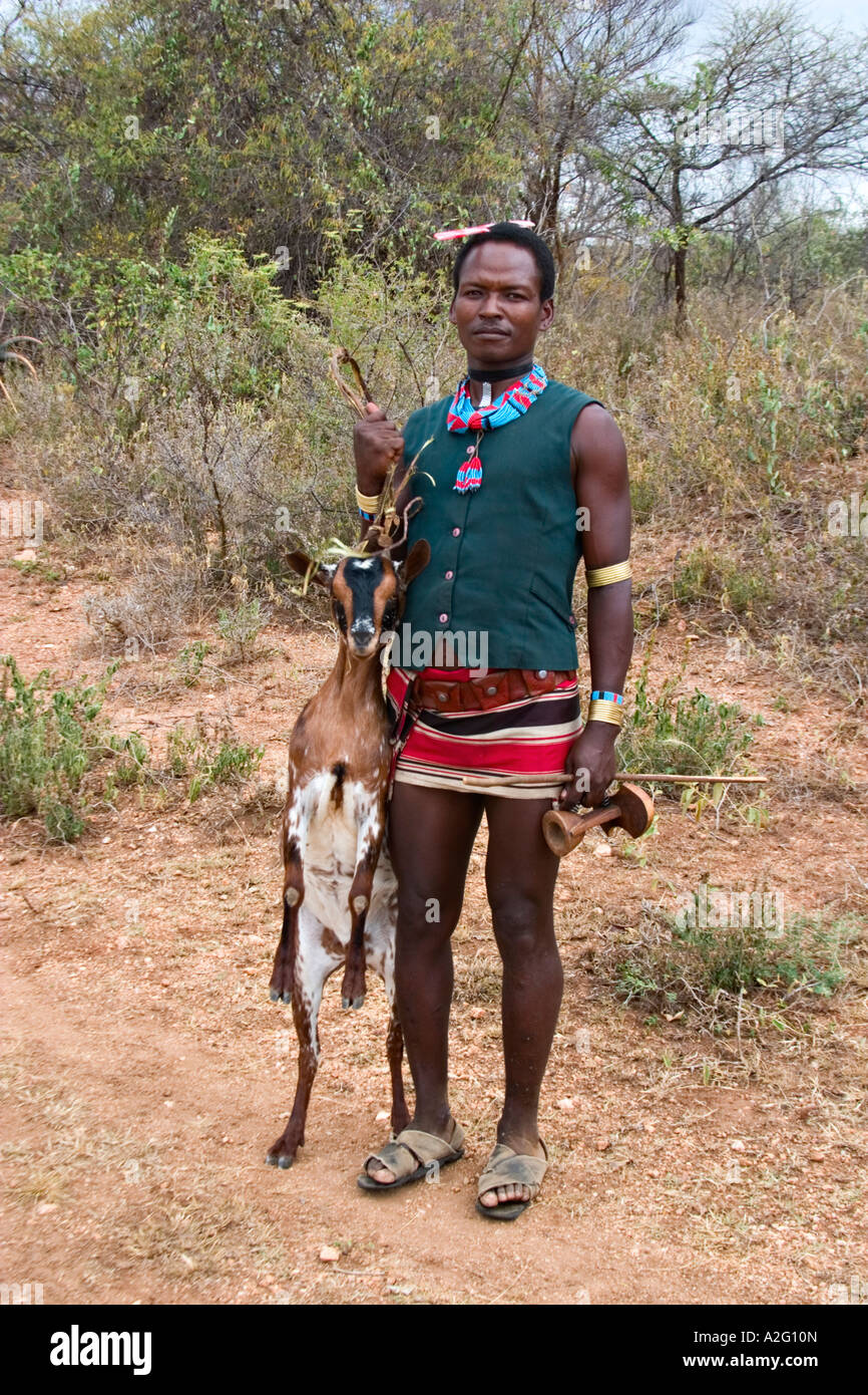 Hamer Mann trägt eine tote Ziege, Omo-Tal in Äthiopien, Afrika Stockfoto