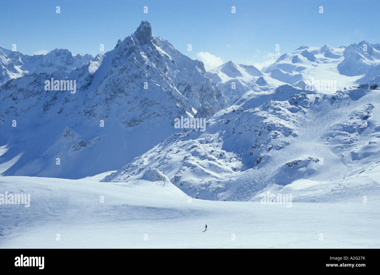 Einsamer Skifahrer bei Sonnenschein mit blauem Himmel Courchevel Ski Pisten in Bergen von Trois Vallees drei Täler Skiregion Frankreich Stockfoto
