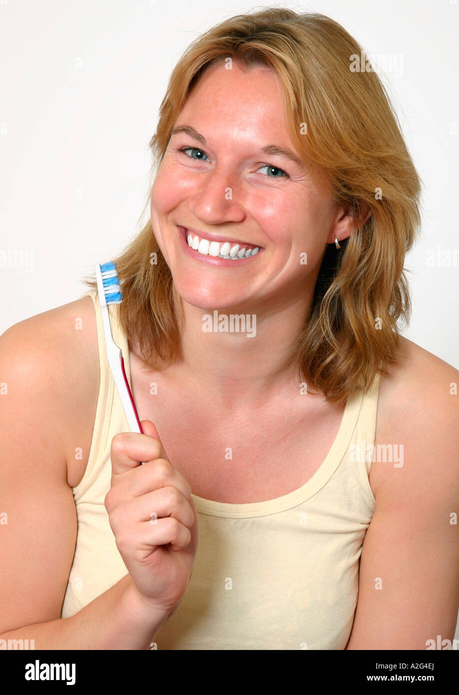 lächelnde Frau mit Zahnbürste Stockfoto