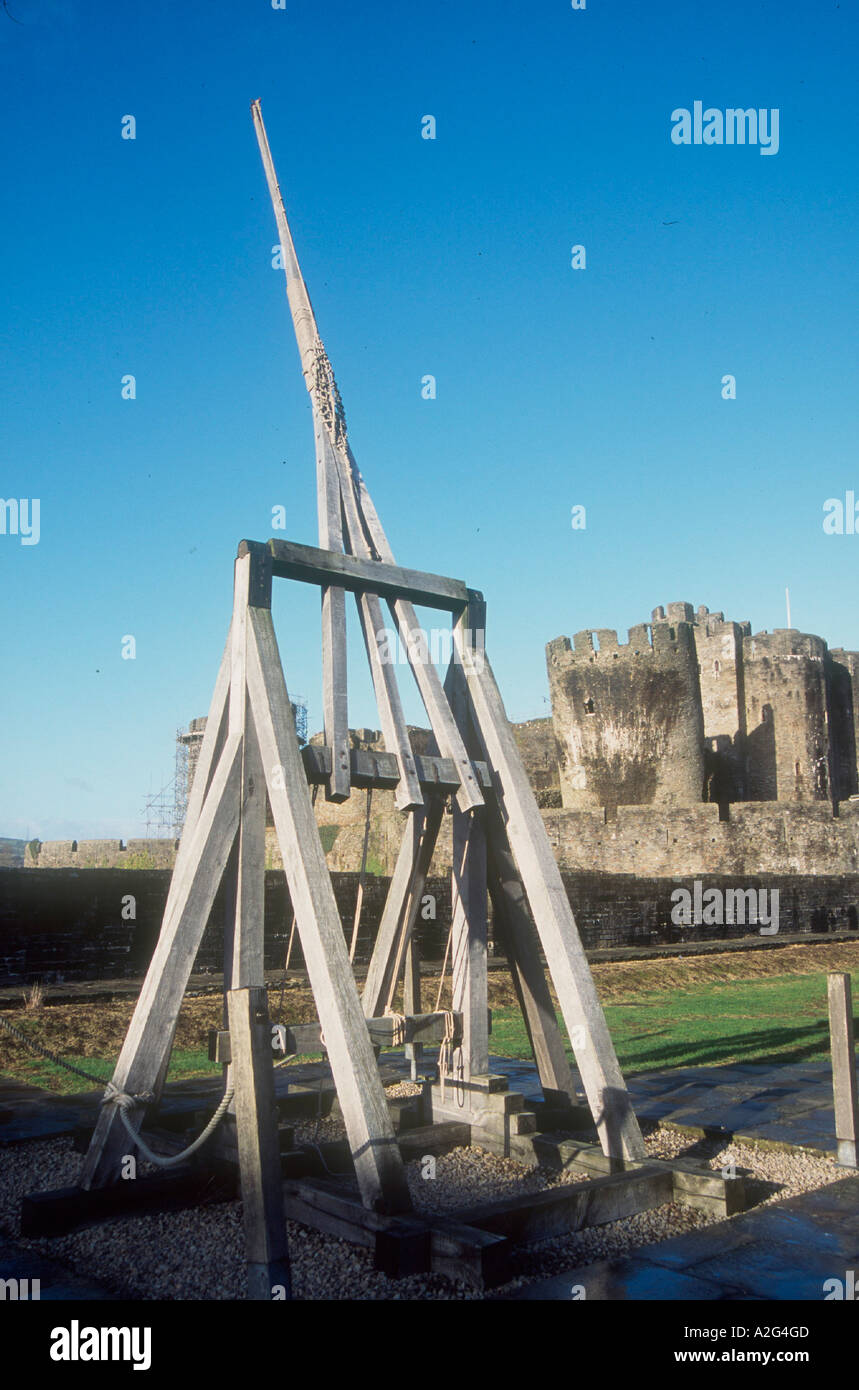 Wales - eine Trebuchet in Caerphilly die Burg mittelalterliche Waffensammlung, mit Schloss im Hintergrund im Bereich Cardiff Stockfoto
