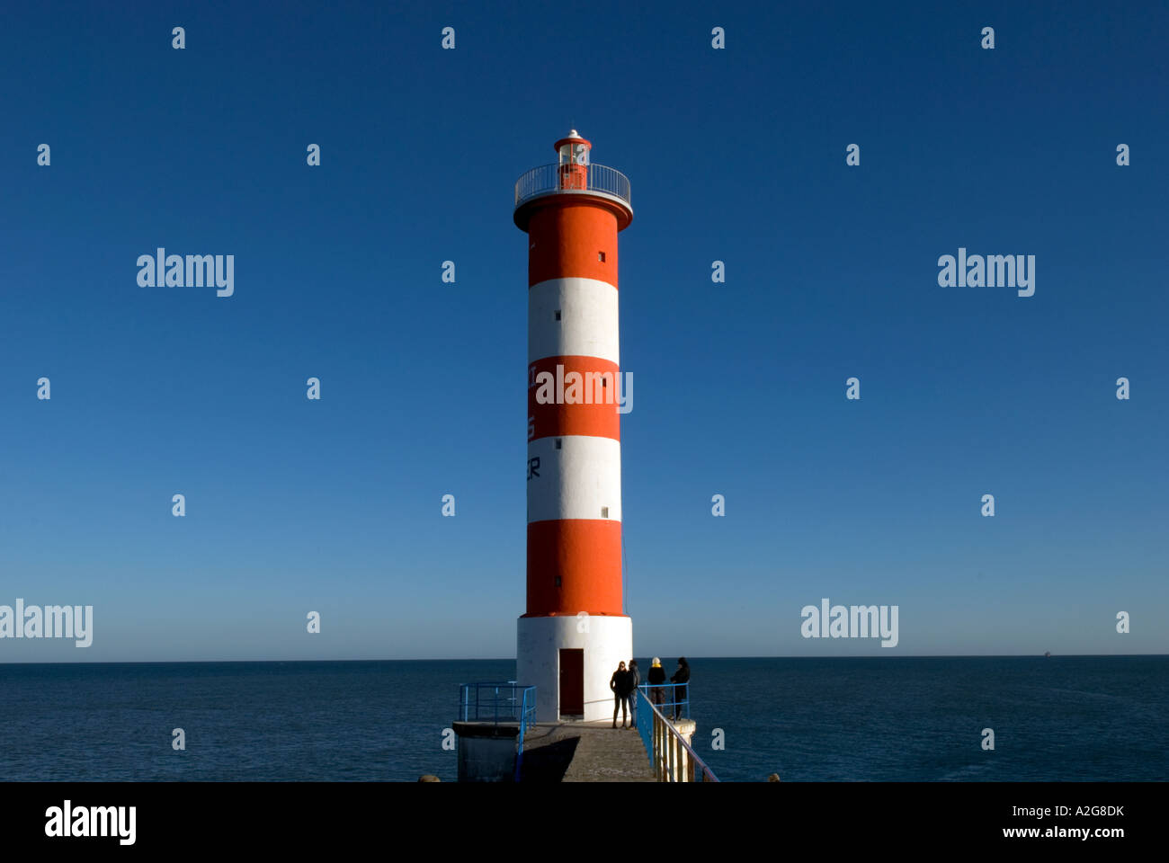 rot-weiße Leuchtturm mit einer Gruppe von Menschen an der Basis Stockfoto