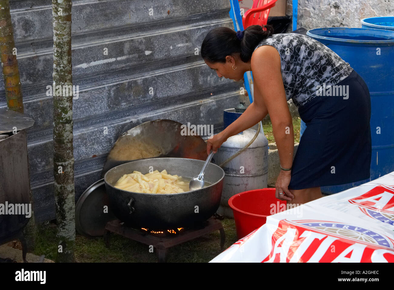 Eine Frau bereitet einige Yuca für den Verkauf. Shes mit einem kleinen gasbetriebenen Herd Stockfoto