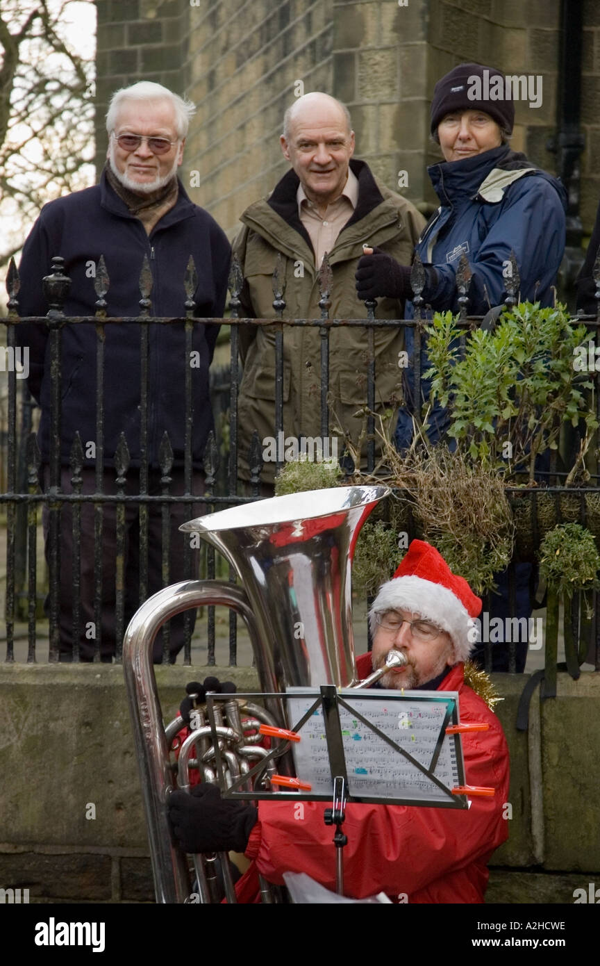 Drei Leute zu beobachten ein Trommler-und Pfeiferkorps Weihnachten spielen Weihnachtslieder Haworth West Yorkshire Stockfoto