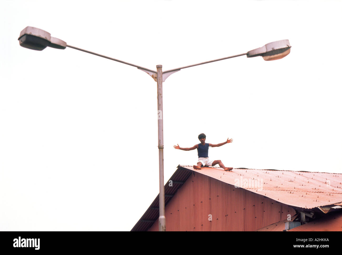 Männer auf dem Dach und Tween Lampe auf einen Laternenpfahl Stockfoto