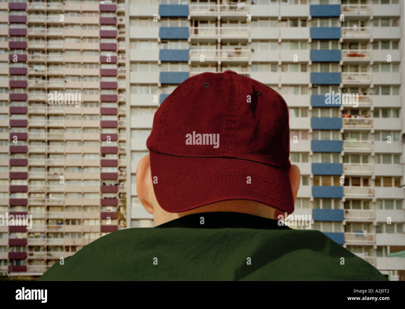Junger Mann im Baseball-Cap mit Blick auf einem Wohnblock. Stockfoto