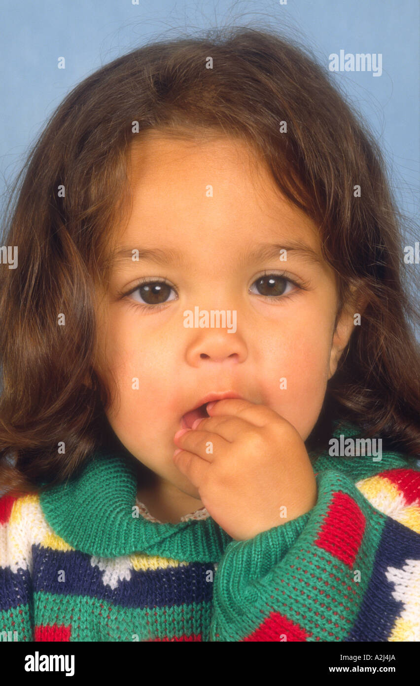 Drei Jahre altes Mädchen mit der Hand im Mund UK Stockfoto