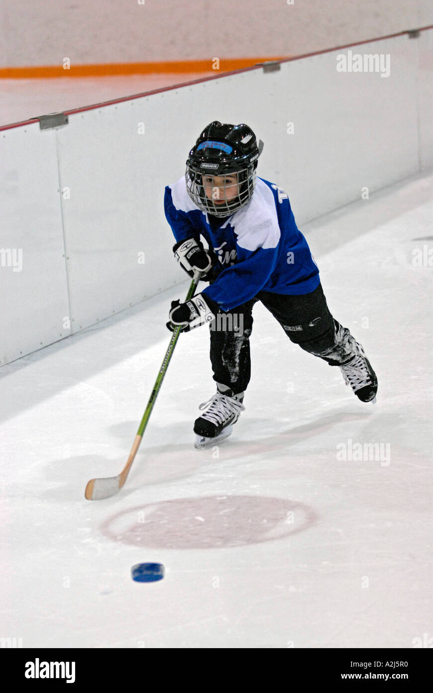 5 Jahre alten Jungen lernen, Eishockey spielen Stockfoto