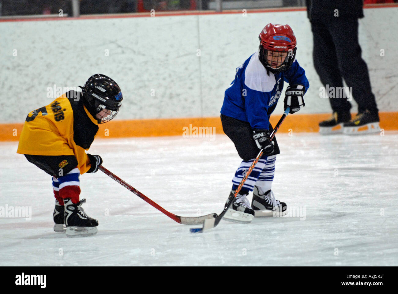 5 Jahre alten Jungen lernen, Eishockey spielen Stockfoto