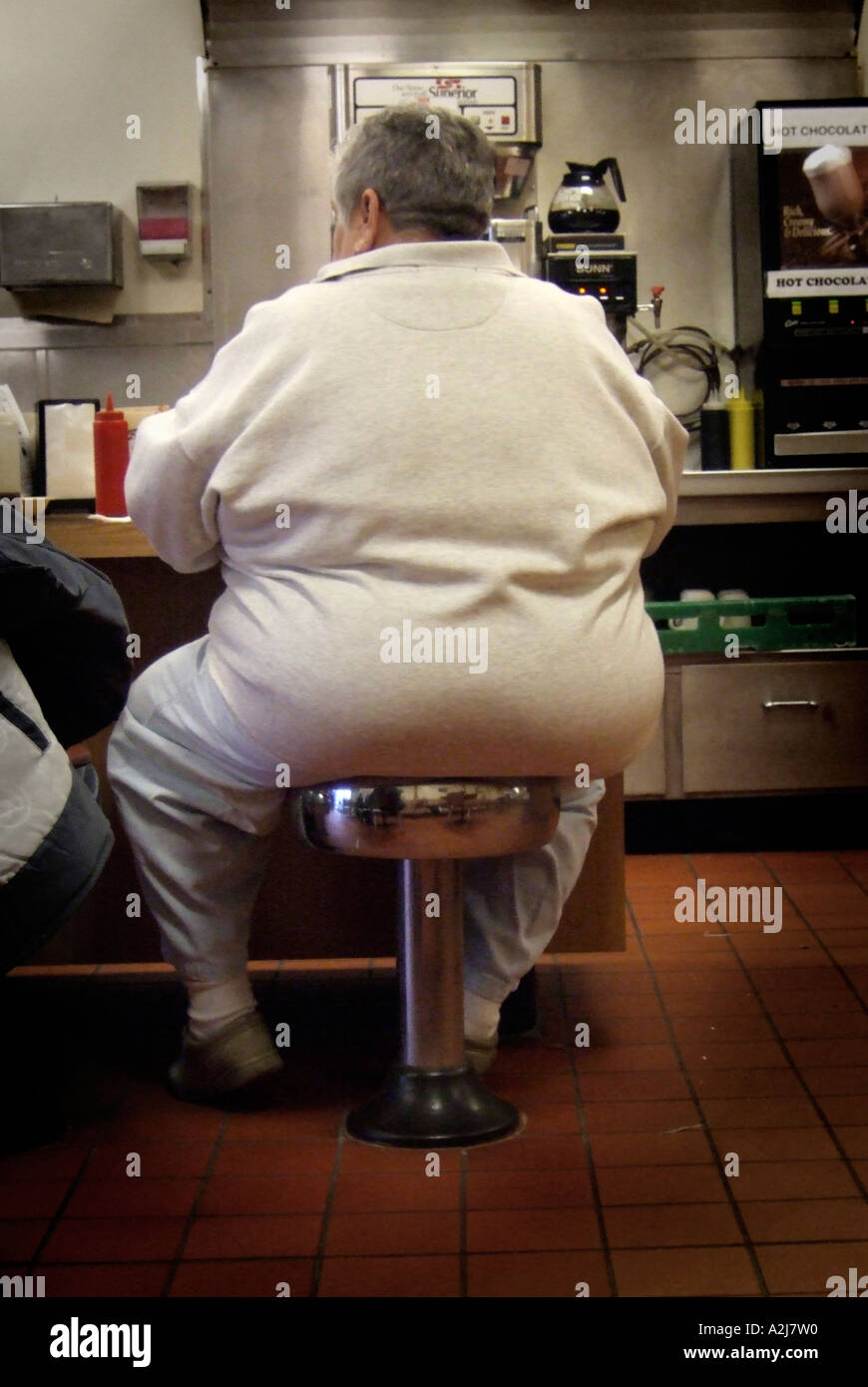 Fett sitzt übergewichtige Frauen Übergewicht an der Theke im Restaurant wenn sie darauf vorbereiten, Essen Stockfoto