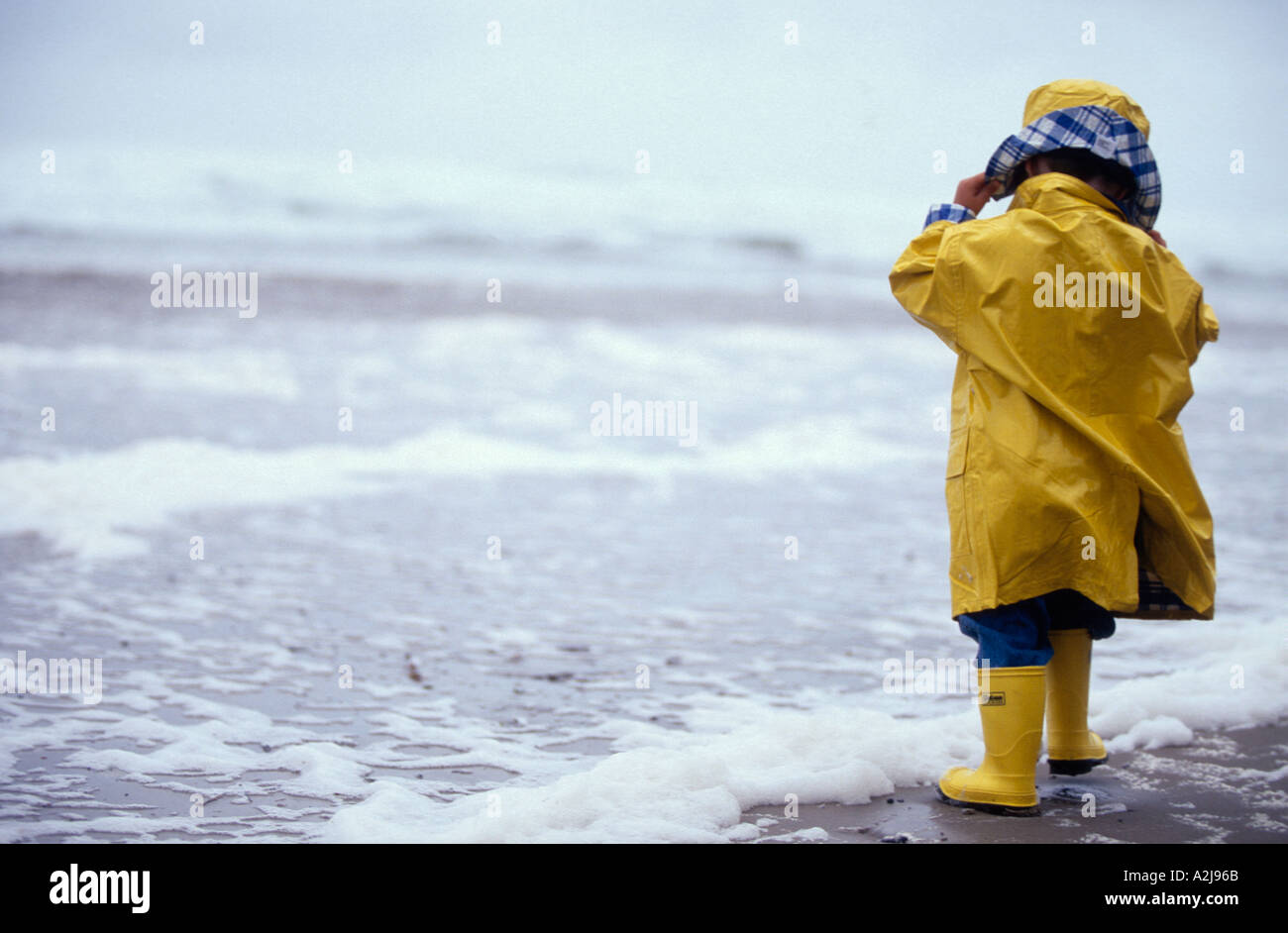 Ein Kleines Kind Trug Einen Gelben Regenmantel Und Regen Stiefel Stehen Im Regen Halten Einen Gelben Regenschirm Stockfotografie Alamy