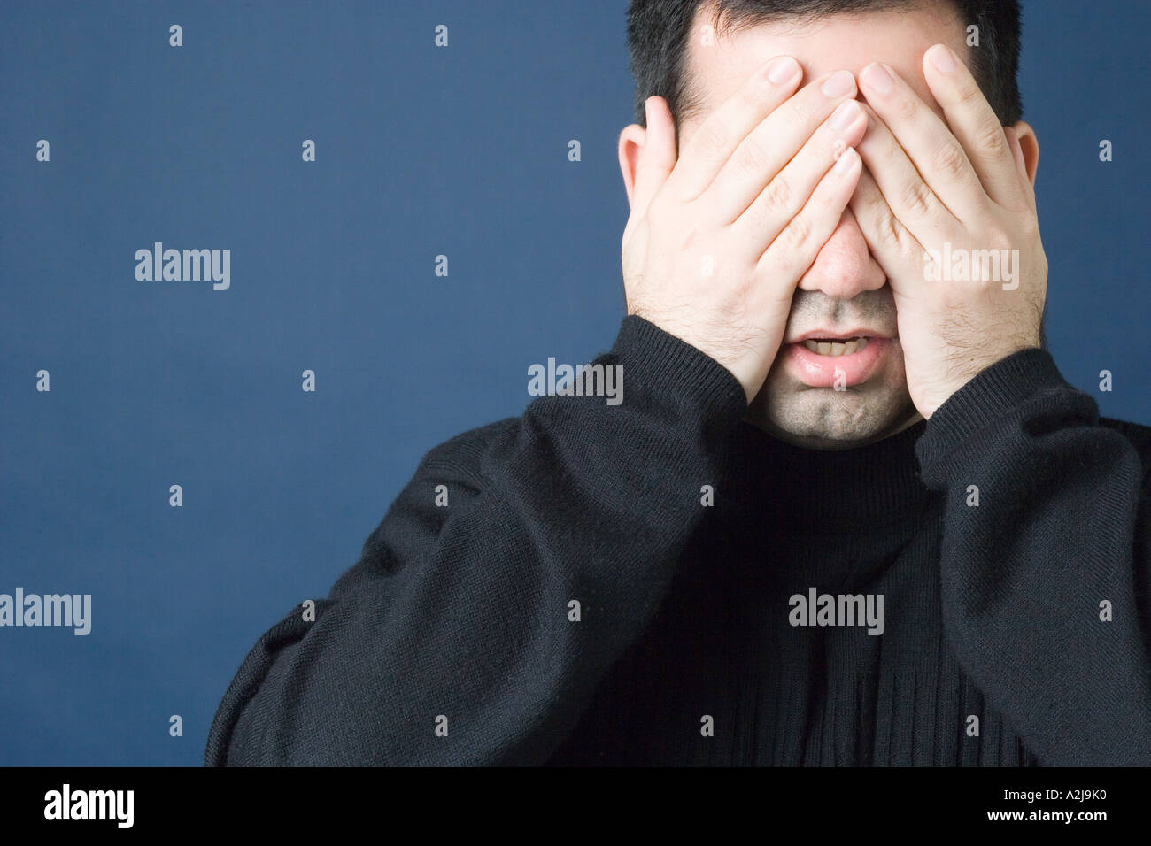 Manndeckung seine Augen mit den Händen Stockfoto