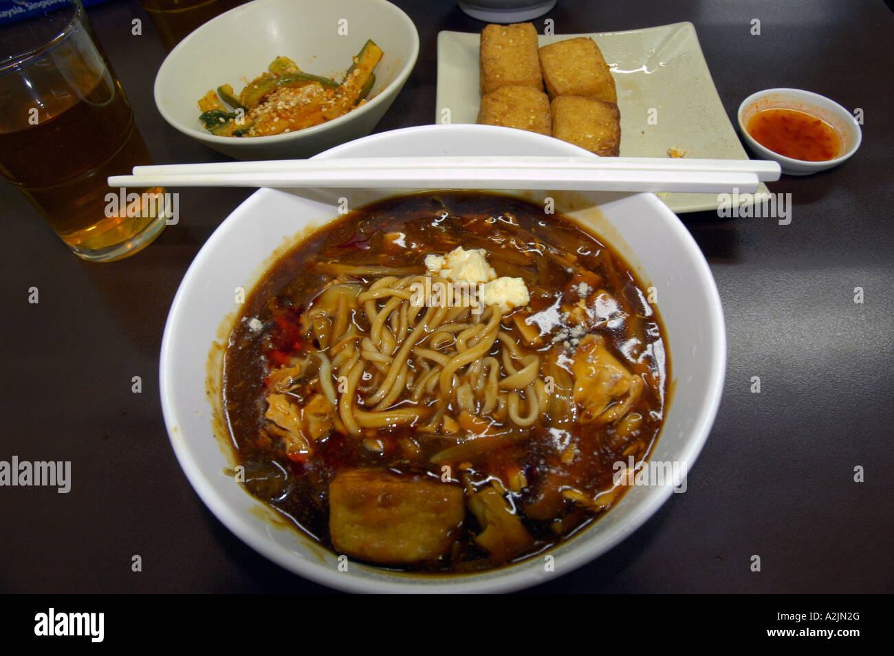 Traditionelle Nudelsuppe (vegetarisch) mit Tofu-Beilage und Stäbchen Stockfoto