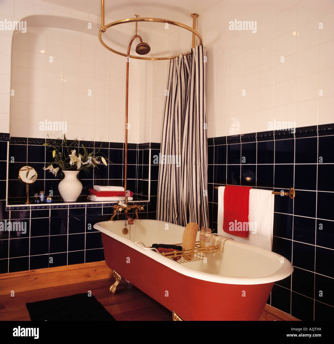 Gestreiften Duschvorhang auf kreisförmigen Schiene oben rot freistehende  Badewanne in schwarz / weiß Bad Stockfotografie - Alamy
