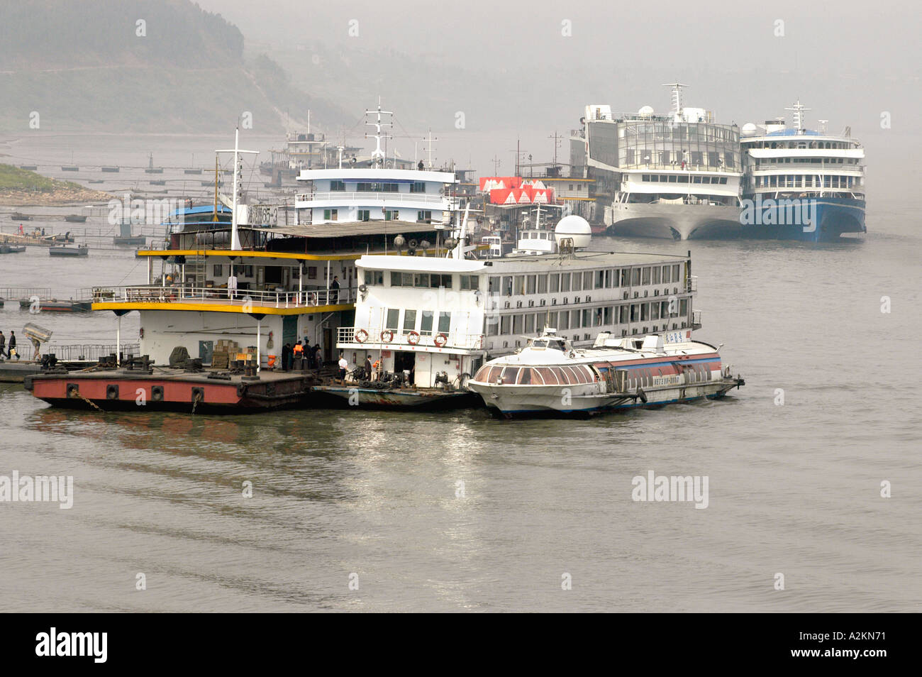 Passagierschiffe und Frachter an einem Flusshafen entlang des Jangtse-Flusses Stockfoto