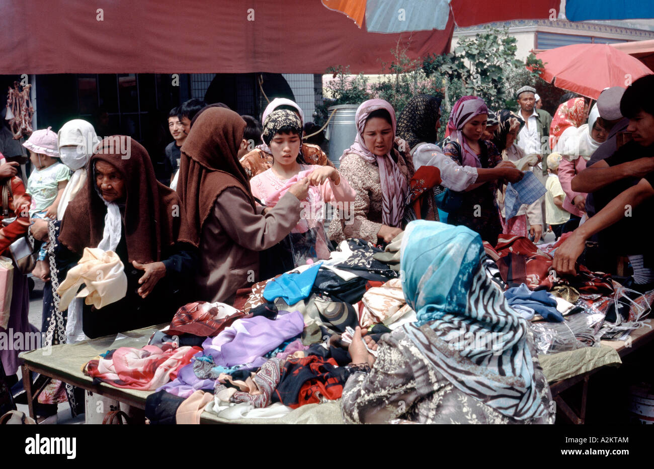 2. Juli 2006 - Markt uigurischen Frauen Auswahl Stoffe in Kashgar Sonntag in der westlichen chinesischen Provinz Xinjiang. Stockfoto