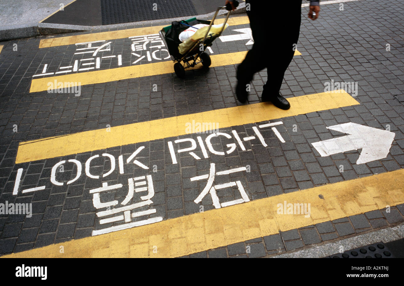 11. September 2006 - Straßenmarkierungen mitzuteilen, Fußgänger auf welche Weise Ausschau nach Verkehr beim Überqueren der Straße in Hongkong. Stockfoto