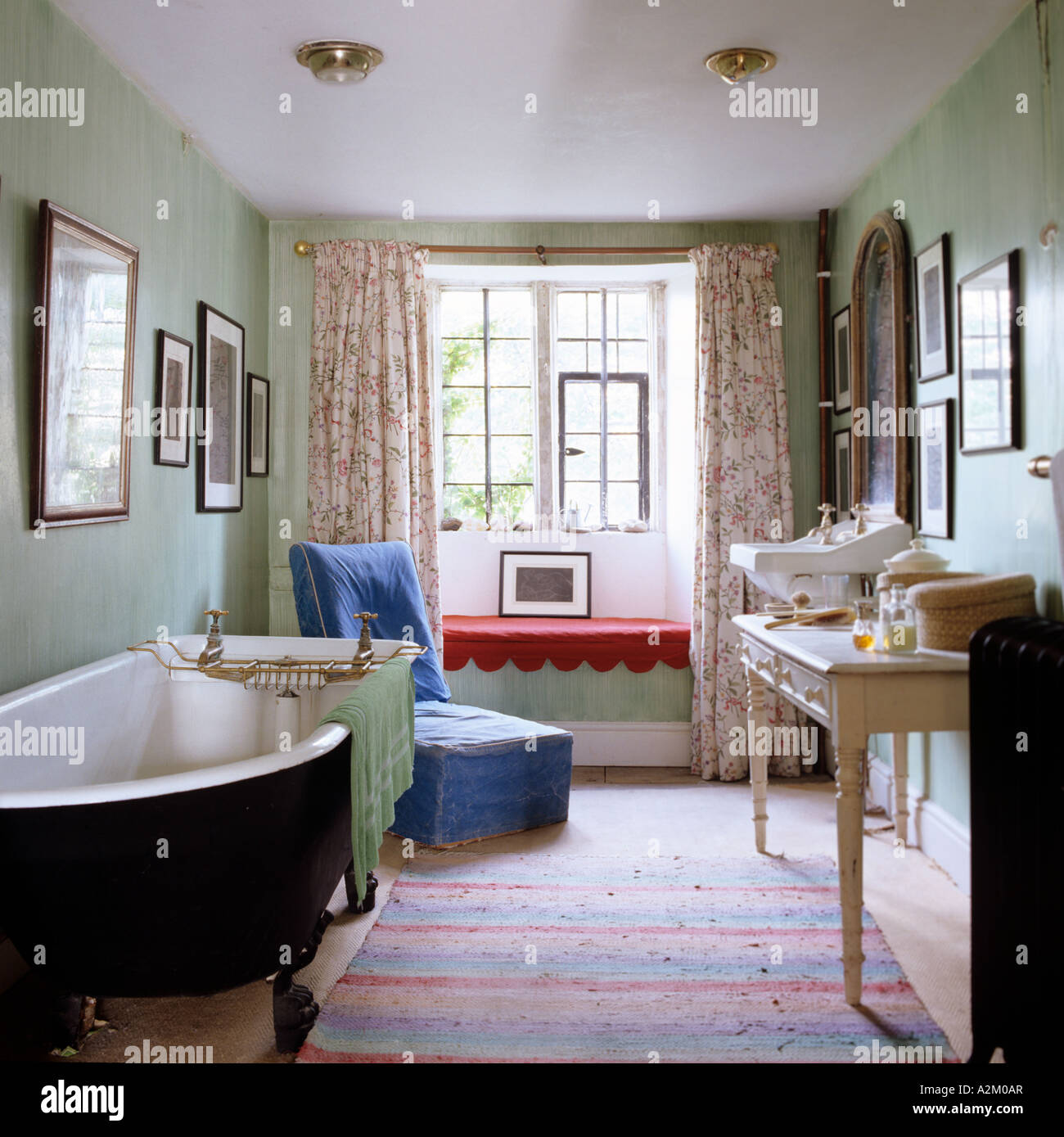 Badezimmer mit freistehender Badewanne, Schminktisch und alten altmodischen Becken. Stockfoto