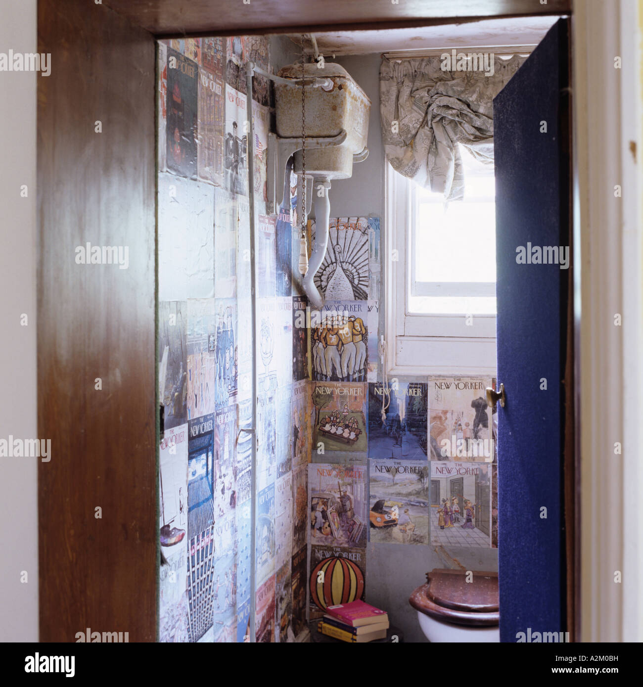 Altmodische WC mit hohen Tank und alte Plakate Stockfoto