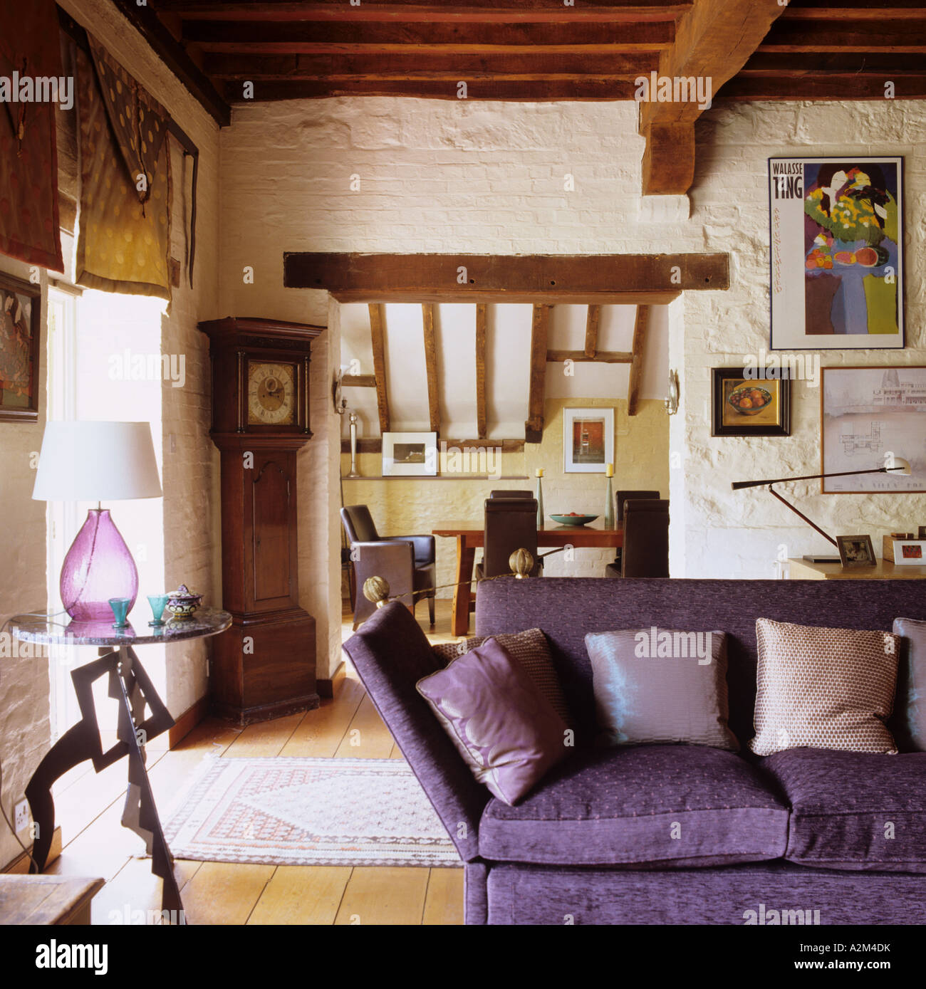 Lila Sofa im Wohnzimmer mit Holzbalken Decke und Katze-Folie Dach ... Lila Sofa im Wohnzimmer mit Holzbalken Decke und Katze-Folie Dach ...