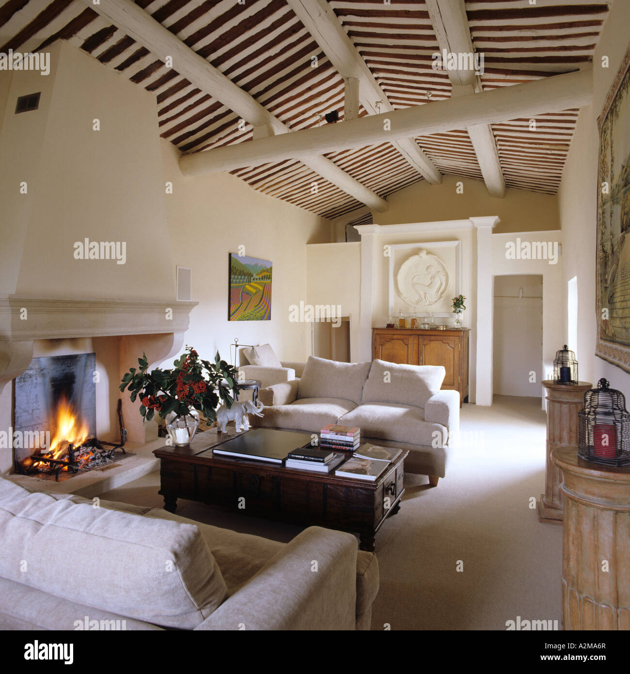 Wohnzimmer mit passenden Sofas, Feuer entzündet und strahlte Decke Stockfoto