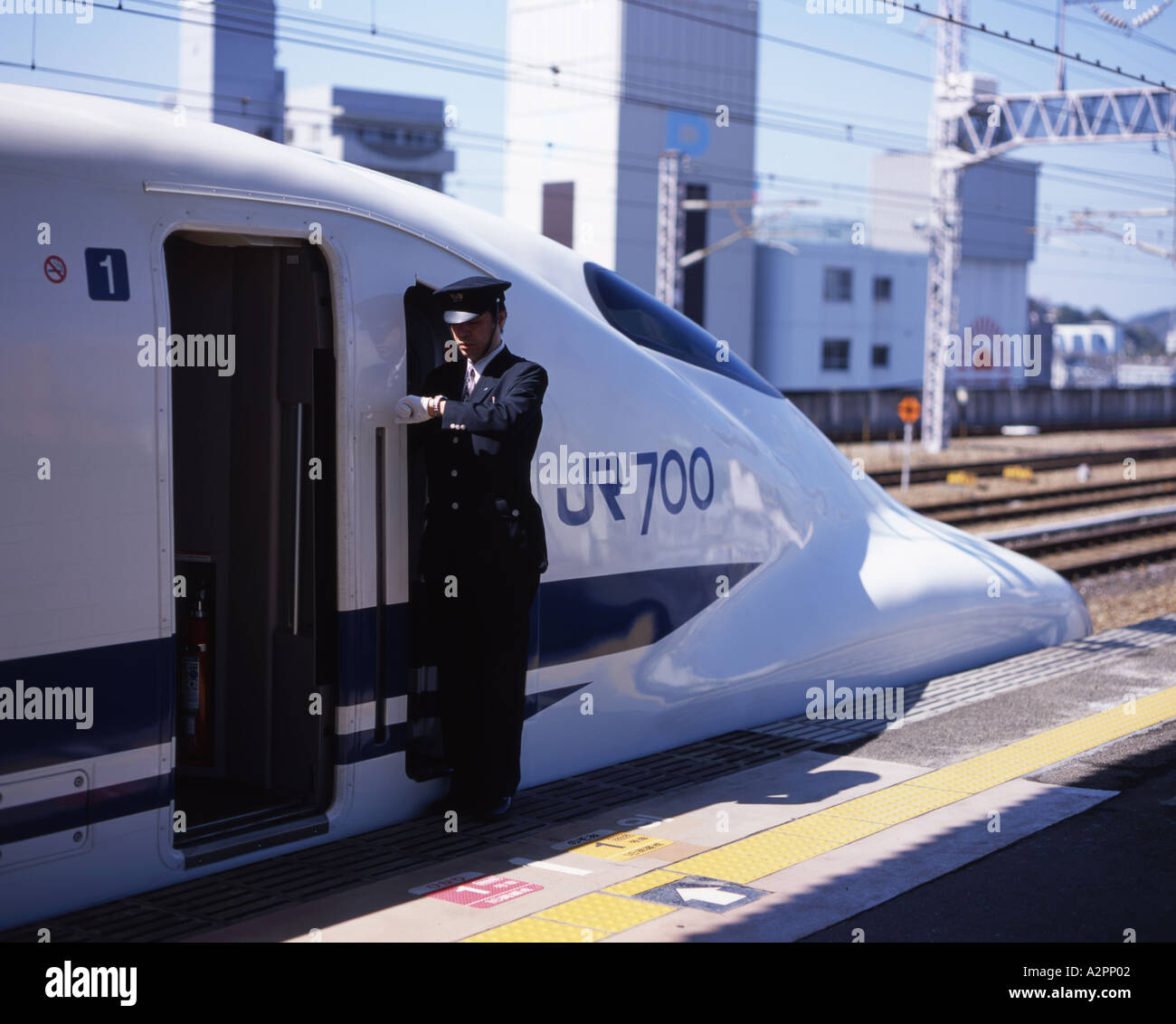 Shinkansen-Hochgeschwindigkeitszug Dirigent blickt seine Uhr Stockfoto