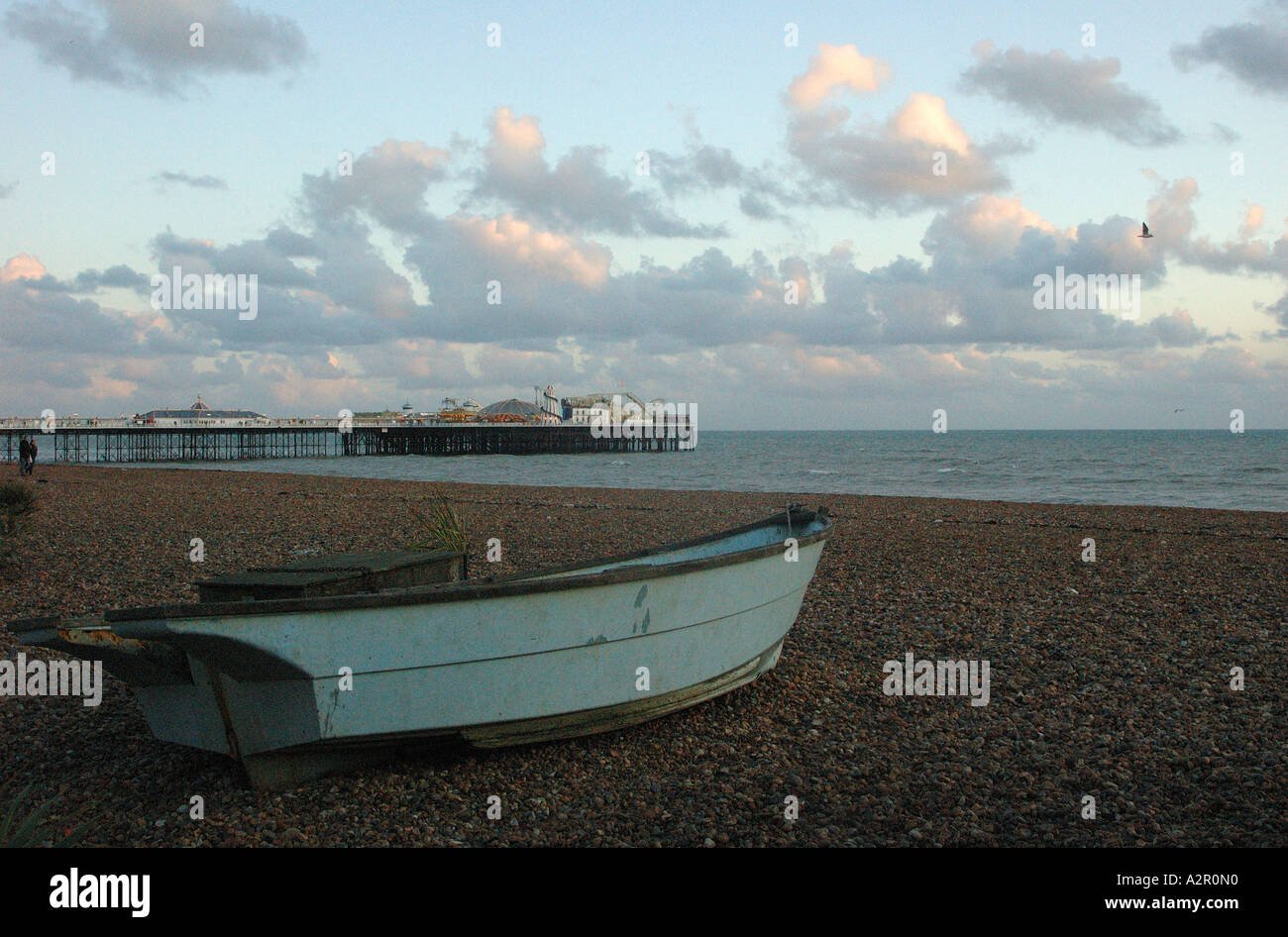 Blick auf Pier von Brighton in der Ferne mit einem Ruderboot im Vordergrund bei Sonnenuntergang Stockfoto