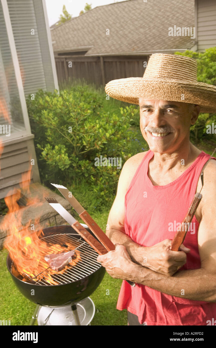 Ein Mann in seinem Garten grillen Stockfoto