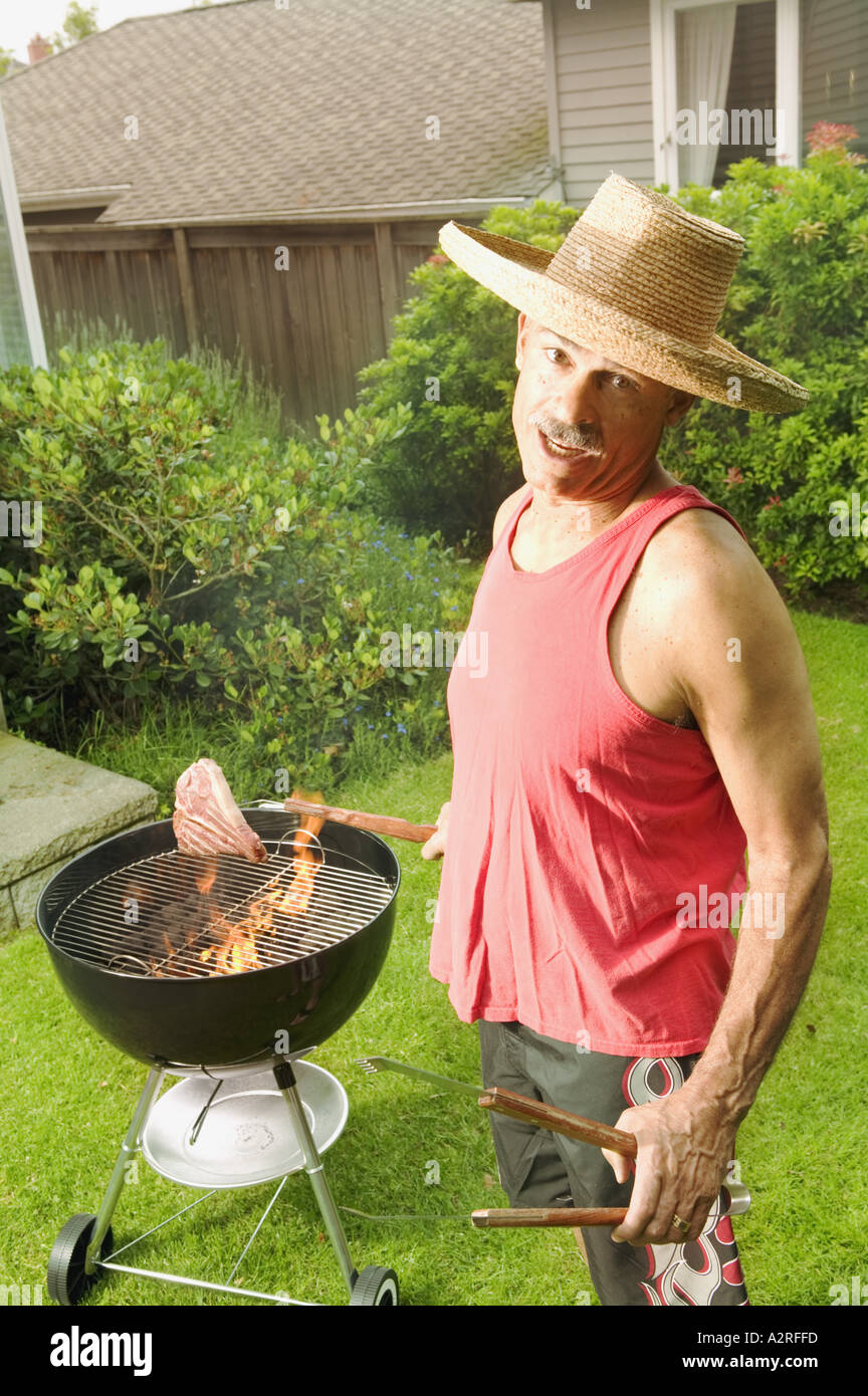 Ein Mann in seinem Garten grillen Stockfoto