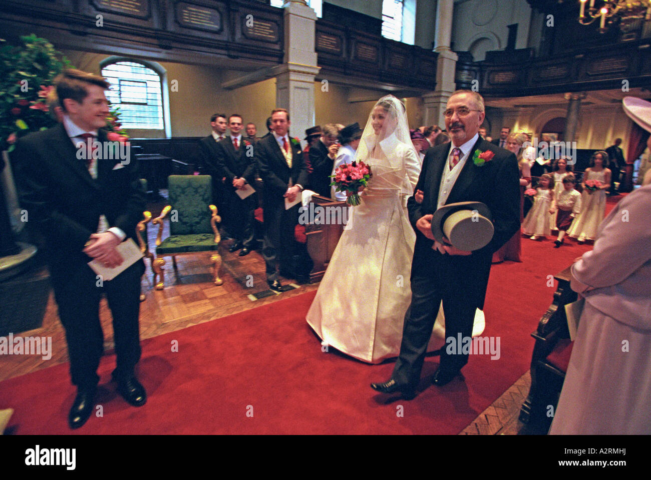 Braut ging den Gang von ihrem Vater an Str. Georges Kirche London Stockfoto