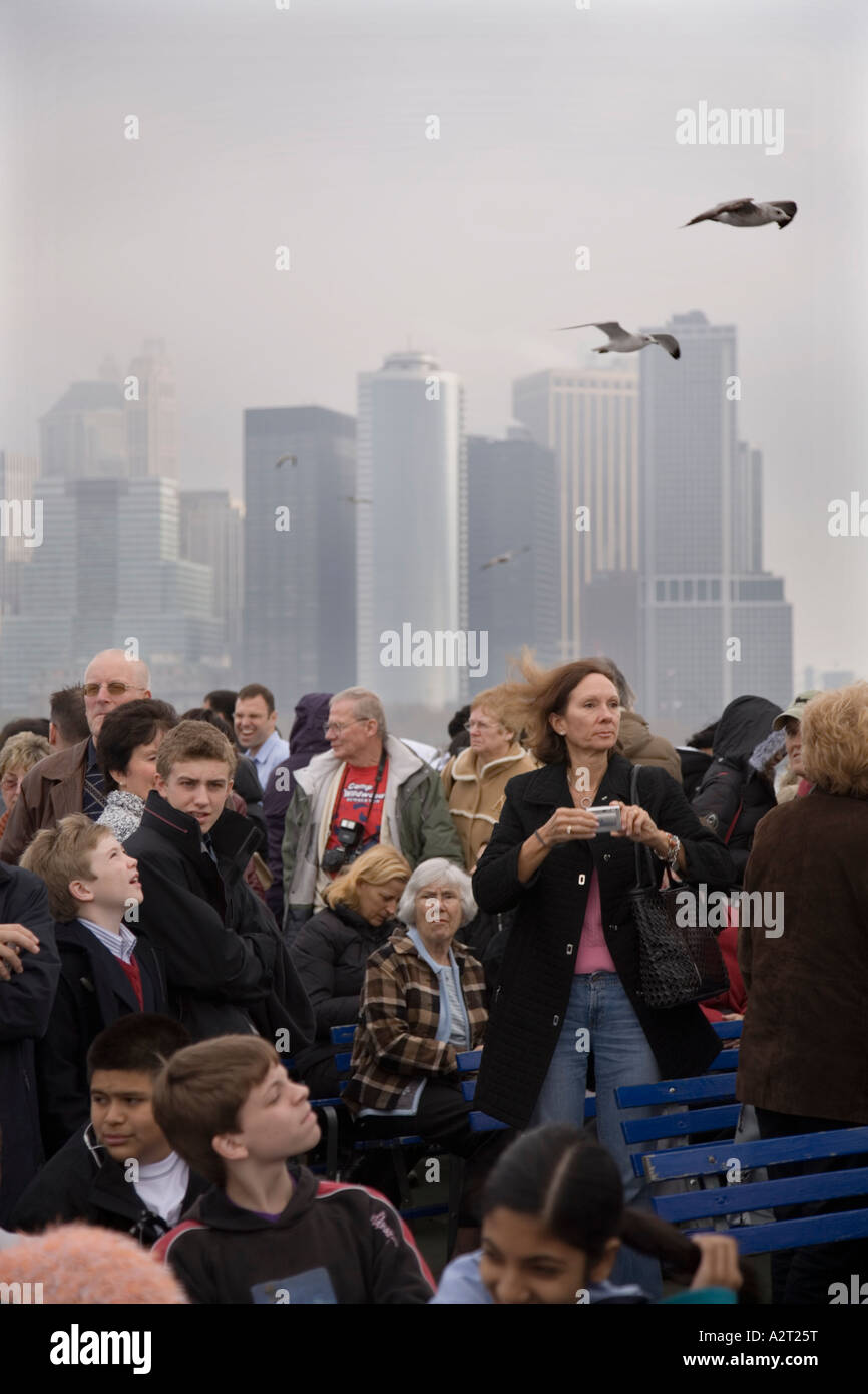 Touristen an Bord die Statue of Liberty Ferry und Ellis Island vom Battery Park von South Ferry Pier New York City Stockfoto