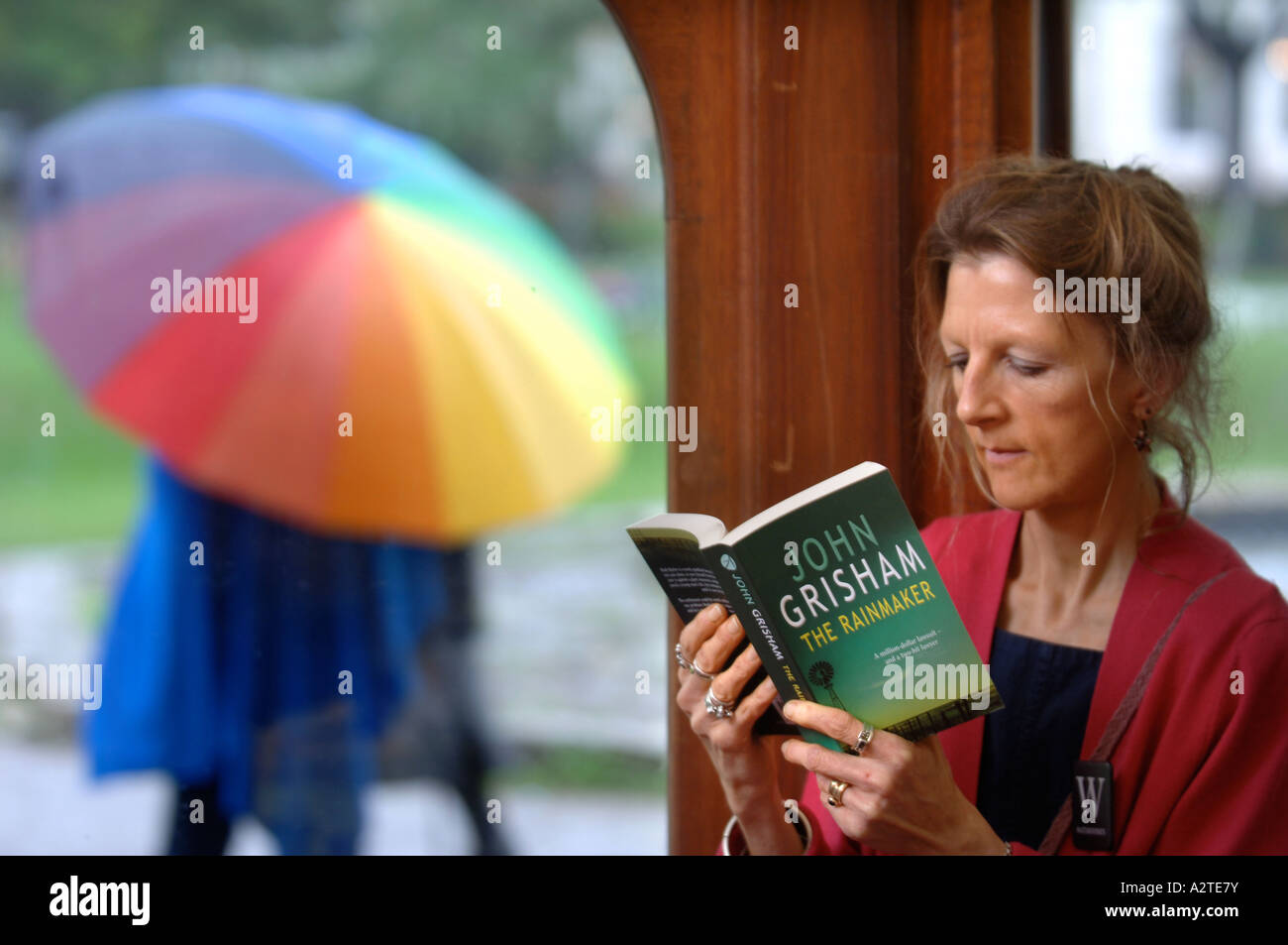 WATERSTONES VERKÄUFERIN LIEST DEN REGENMACHER VON JOHN GRISHAM AN DER CHELTENHAM LITERARISCHE FESTIVAL UK Stockfoto