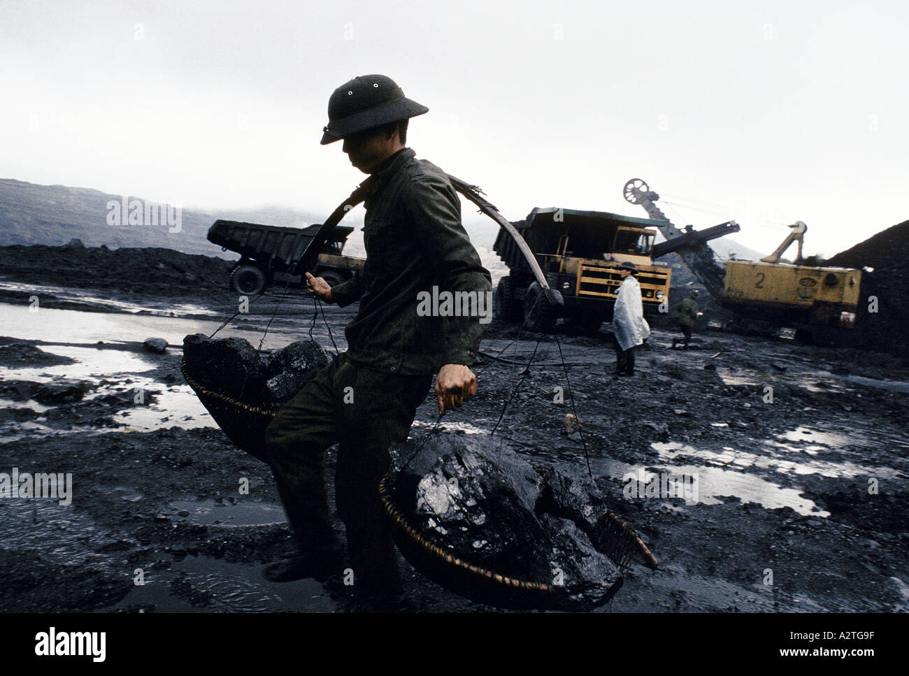 Schwarzgold von Vietnam in einem Tagebau Kohle mine begann vor 40 Jahren von der französischen Arbeitnehmer trägt große Brocken Kohle in Körben aufgehängt vom Joch der Arbeit ist vor allem harte körperliche Arbeit Zahlung ist nur bei der Arbeit zur Verfügung Cam pha 1993 Stockfoto